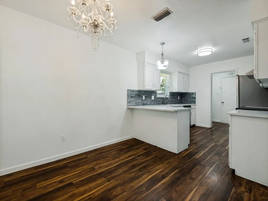 Wood-finish flooring throughout, complemented by a crystal chandelier and recessed lighting