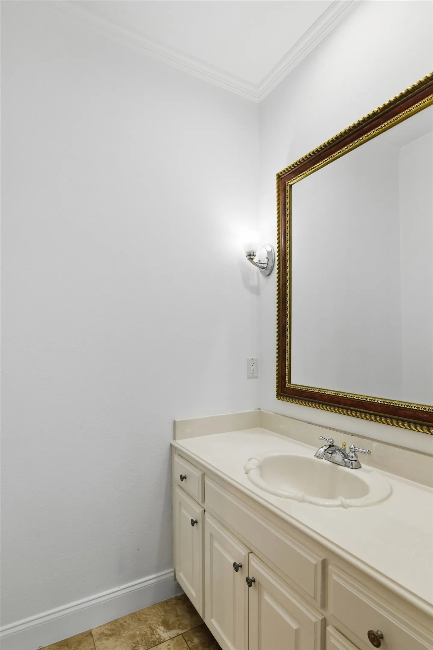 White vanity with an integrated sink, polished chrome faucet, and a decorative framed mirror