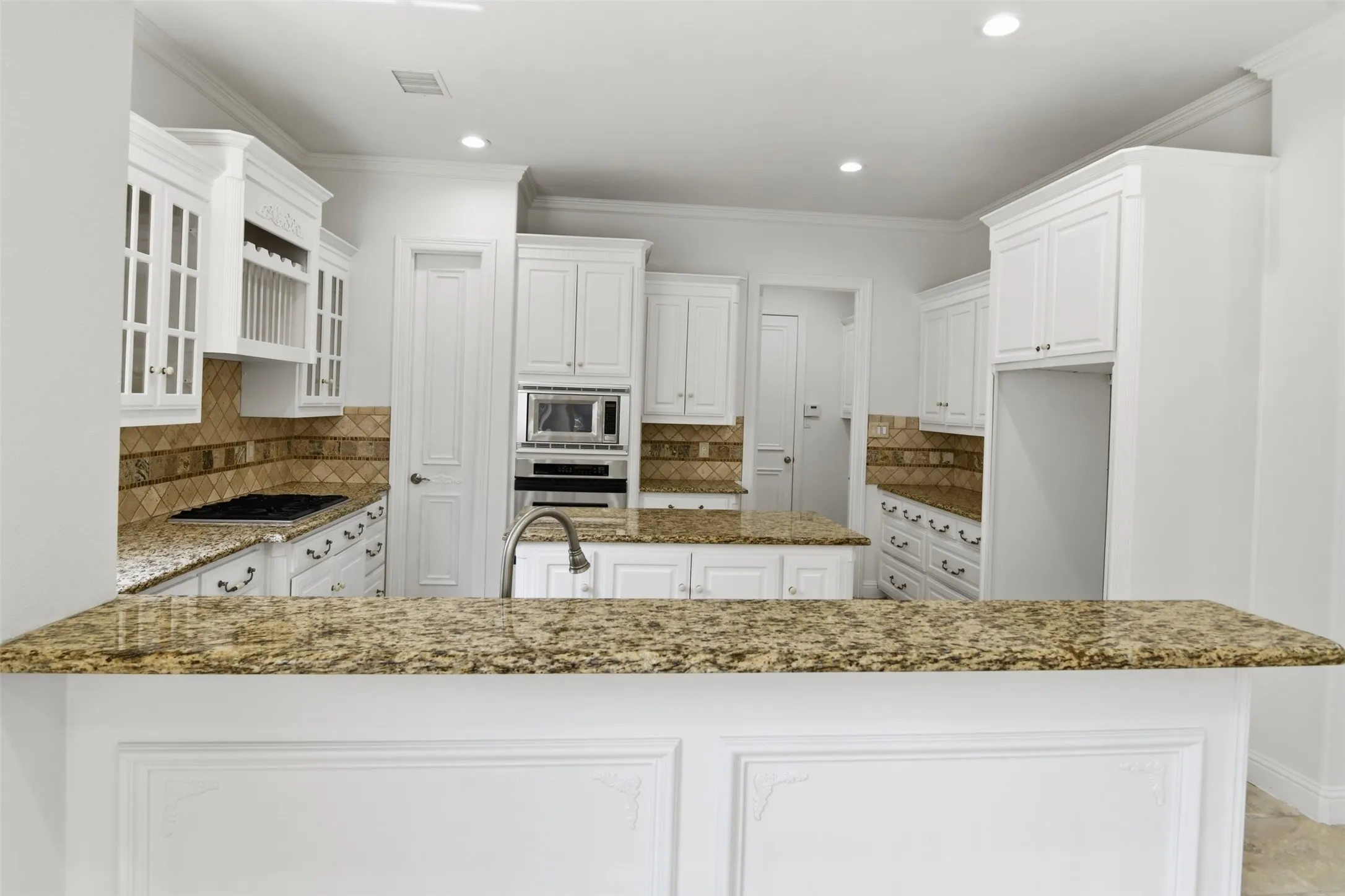 Kitchen featuring white cabinetry, stone-finish countertops, tiled backsplash, and recessed lighting