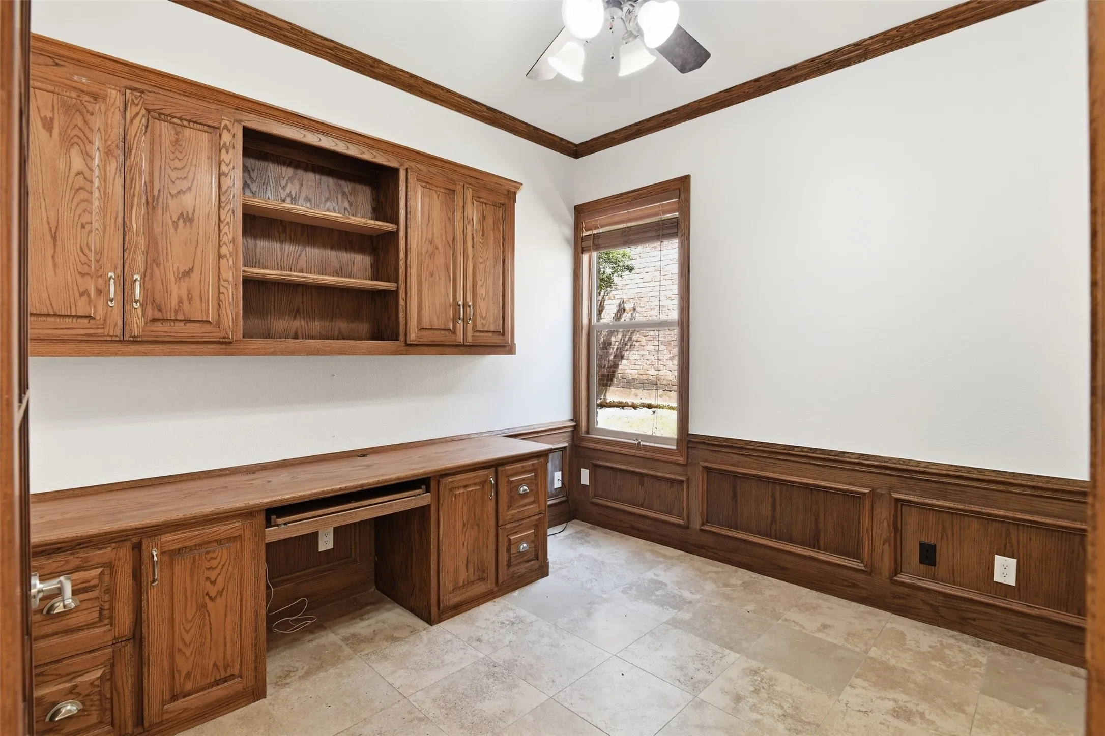 Built-in wood cabinetry, integrated desk space, wood paneling, wood window trim, and tile flooring