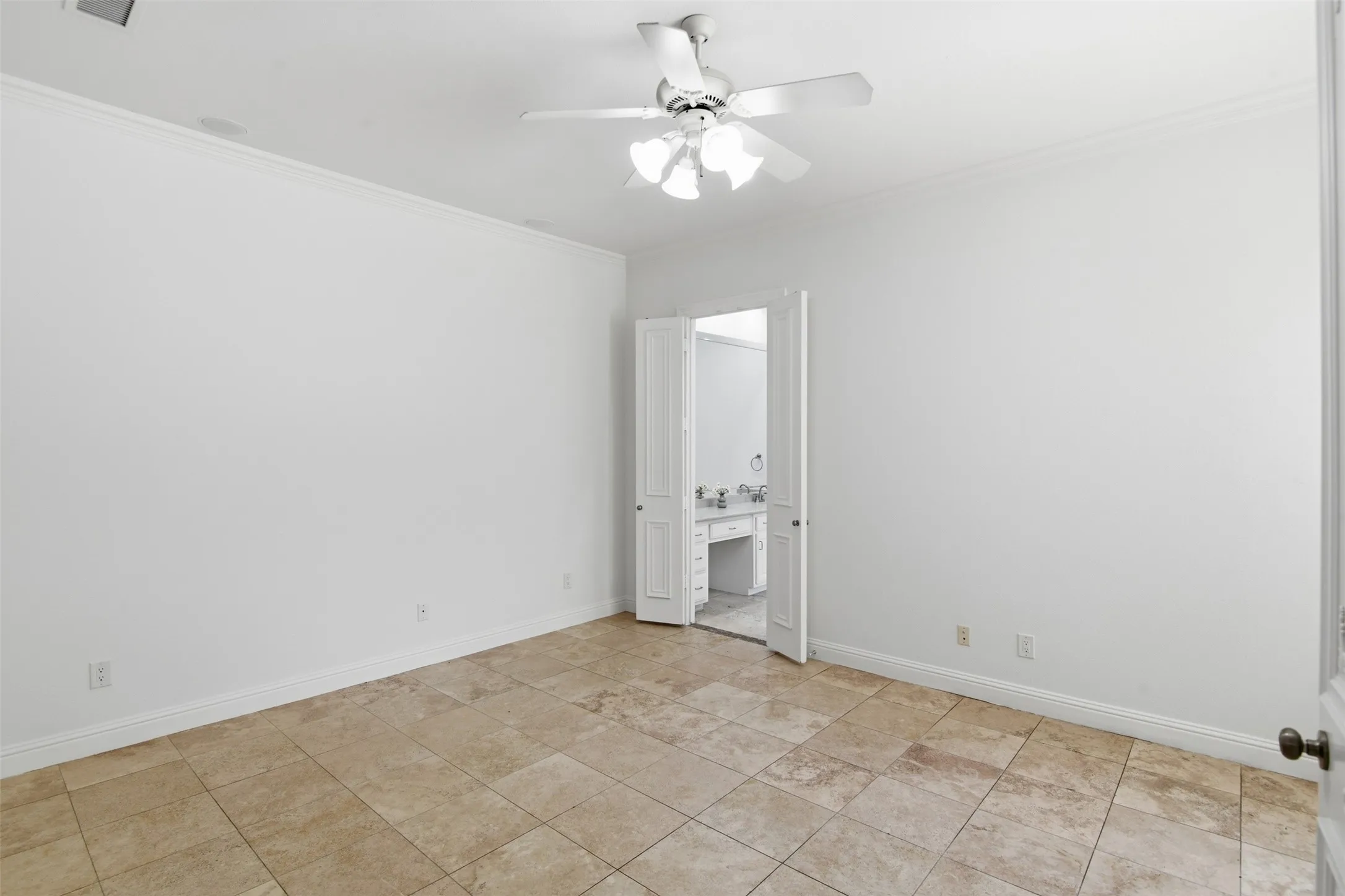 Neutral-toned tile flooring, white walls, and a ceiling fan with integrated lighting
