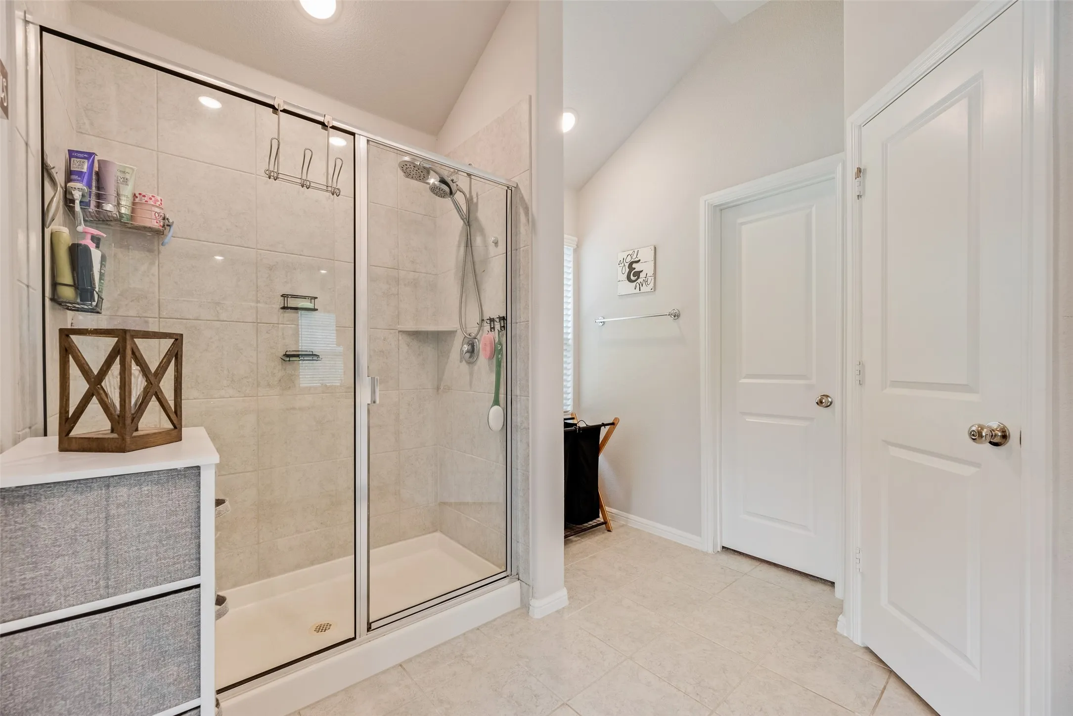 Glass-enclosed shower with tile surround and integrated shower niche