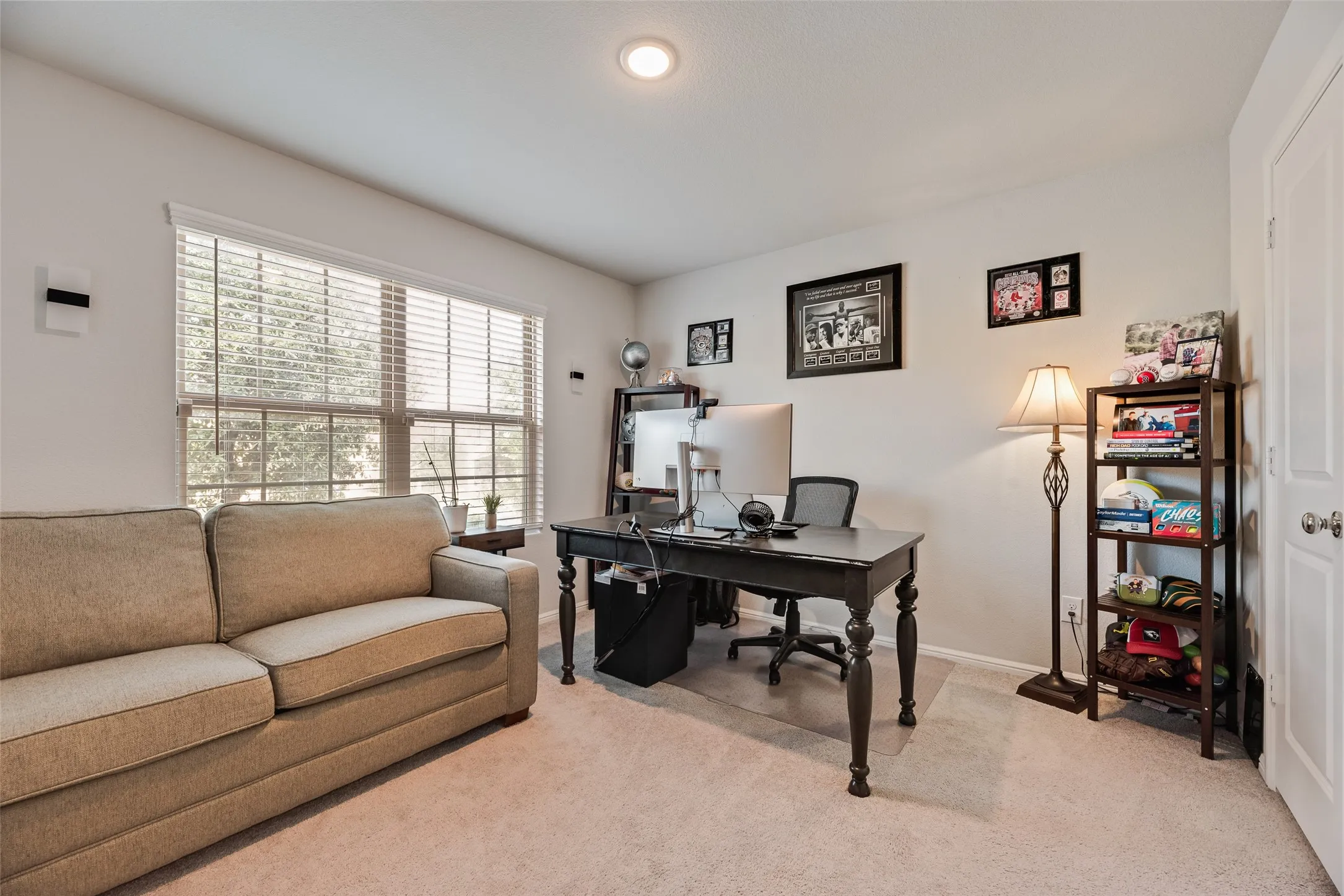 Recessed ceiling lighting, neutral wall paint, window with horizontal blinds, light-toned carpeting, and a white paneled door