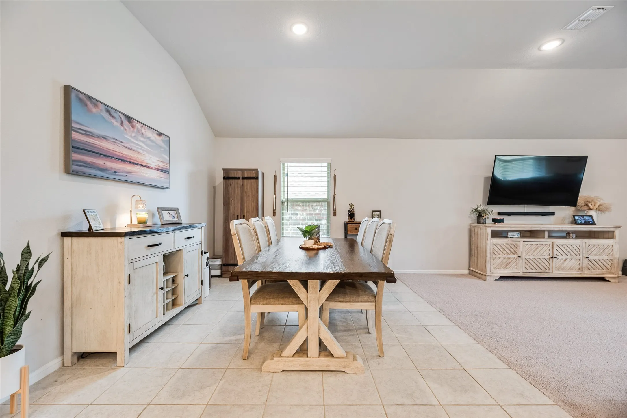 Vaulted ceiling, recessed lighting, tile flooring, window with blinds, and carpeted area