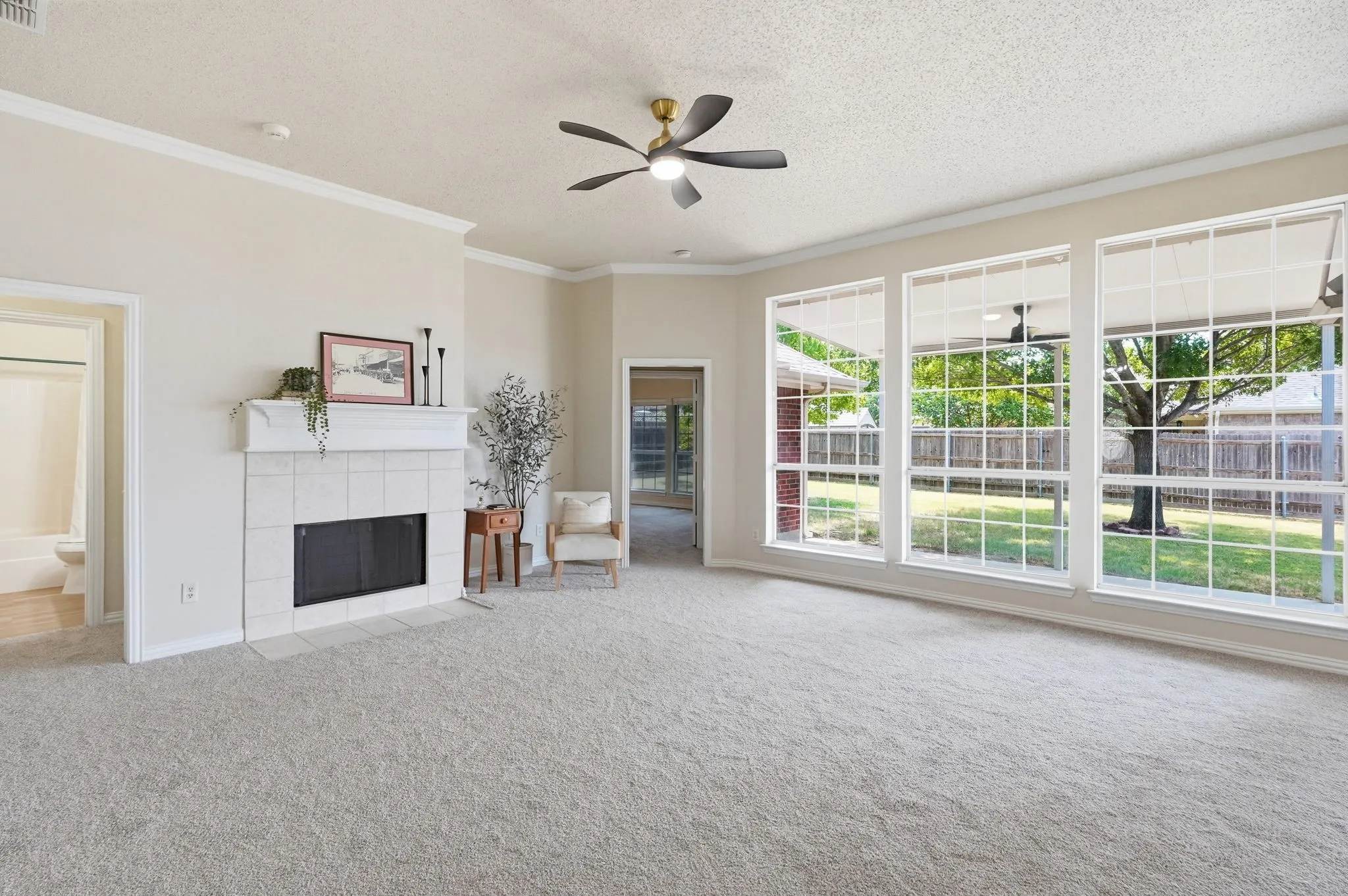 Beautiful living room with impressive wall of windows with view into backyard & access to primary bedroom