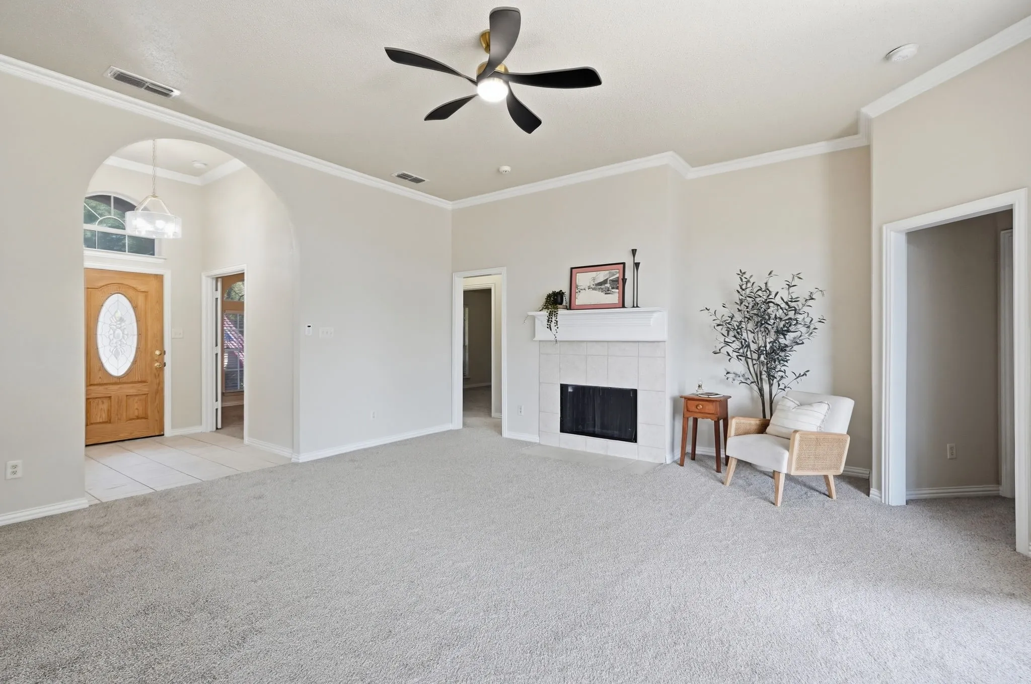 Spacious living room featuring updated paint, flooring, lighting & cozy wood-burning fireplace