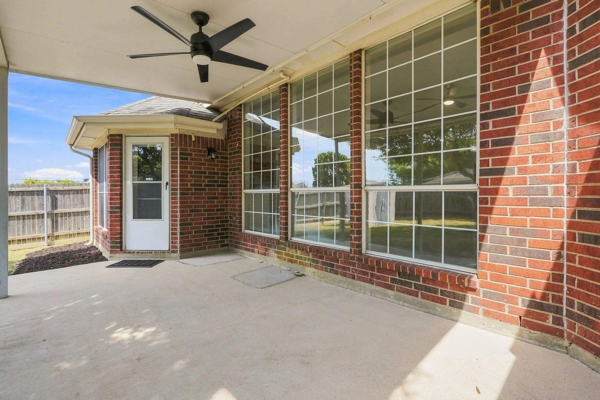 Large covered back patio with ceiling fan