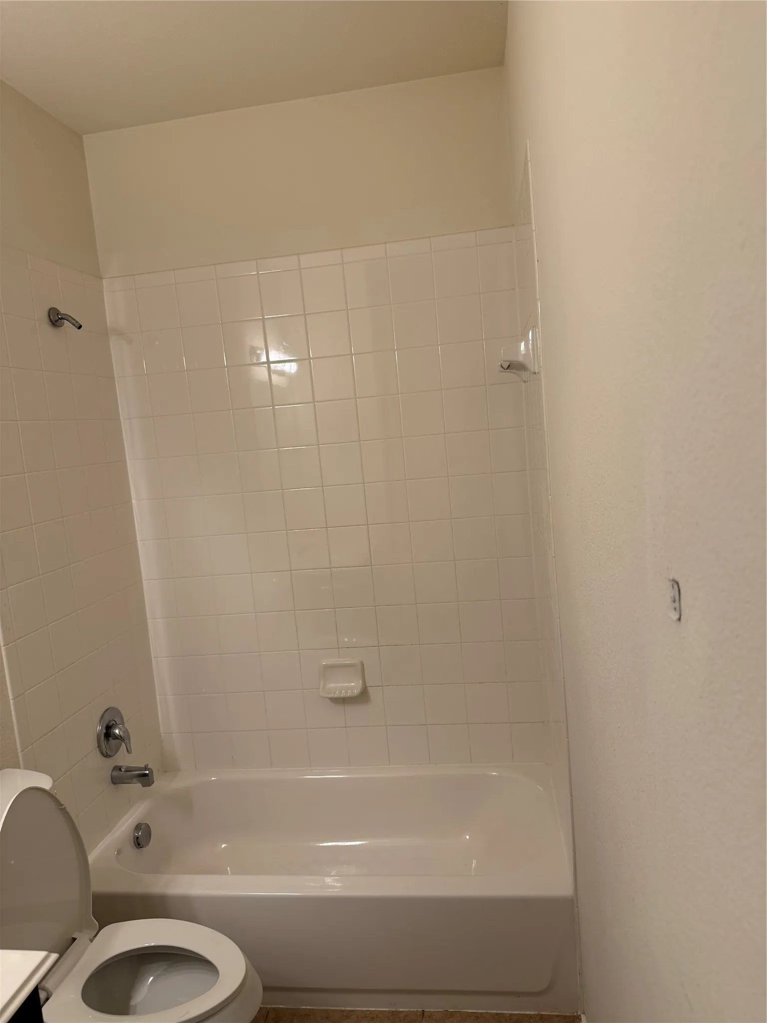 Bathtub with white subway tile surround and chrome fixtures
