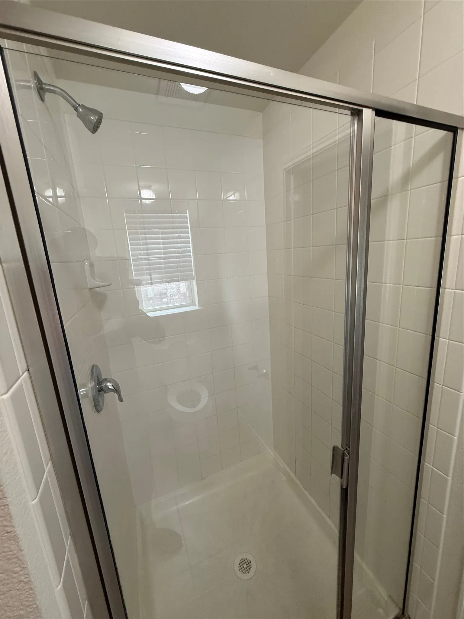 Enclosed shower with clear glass sliding doors and a chrome shower head