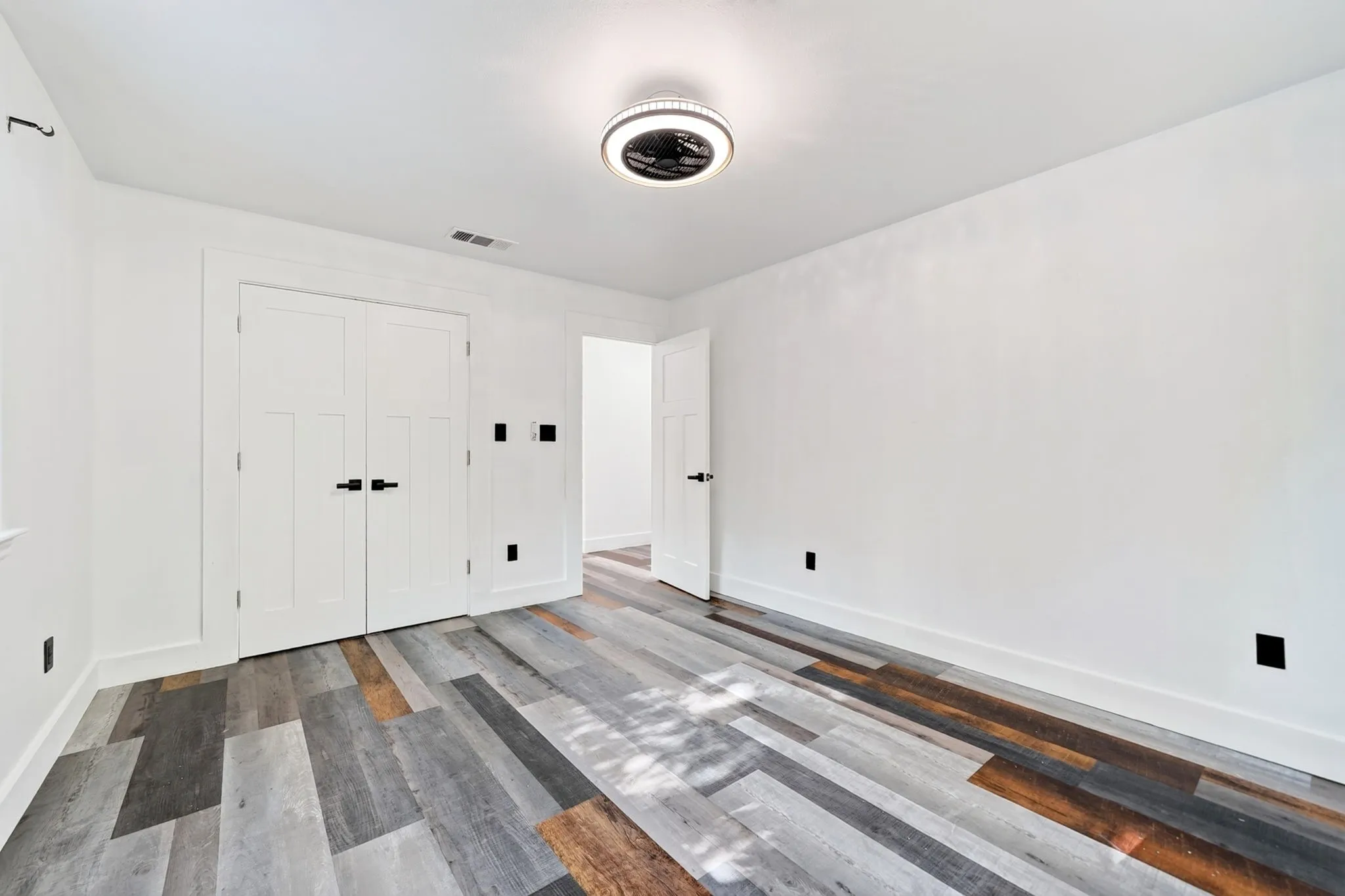 Wood-finish flooring, white walls, and a contemporary ceiling fixture