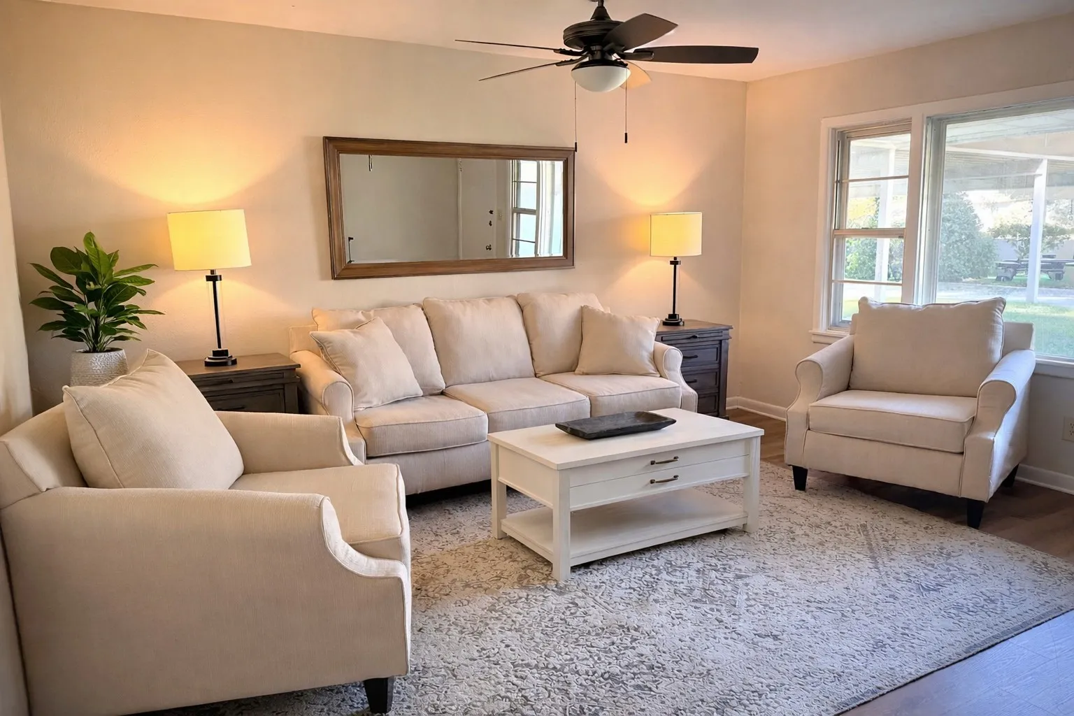 Expansive room featuring a ceiling fan with integrated lighting, a large window with white trim, and wood-finish​​‌​​​​‌​​‌‌​‌‌​​​‌‌​‌​‌​‌​​​‌​​ flooring