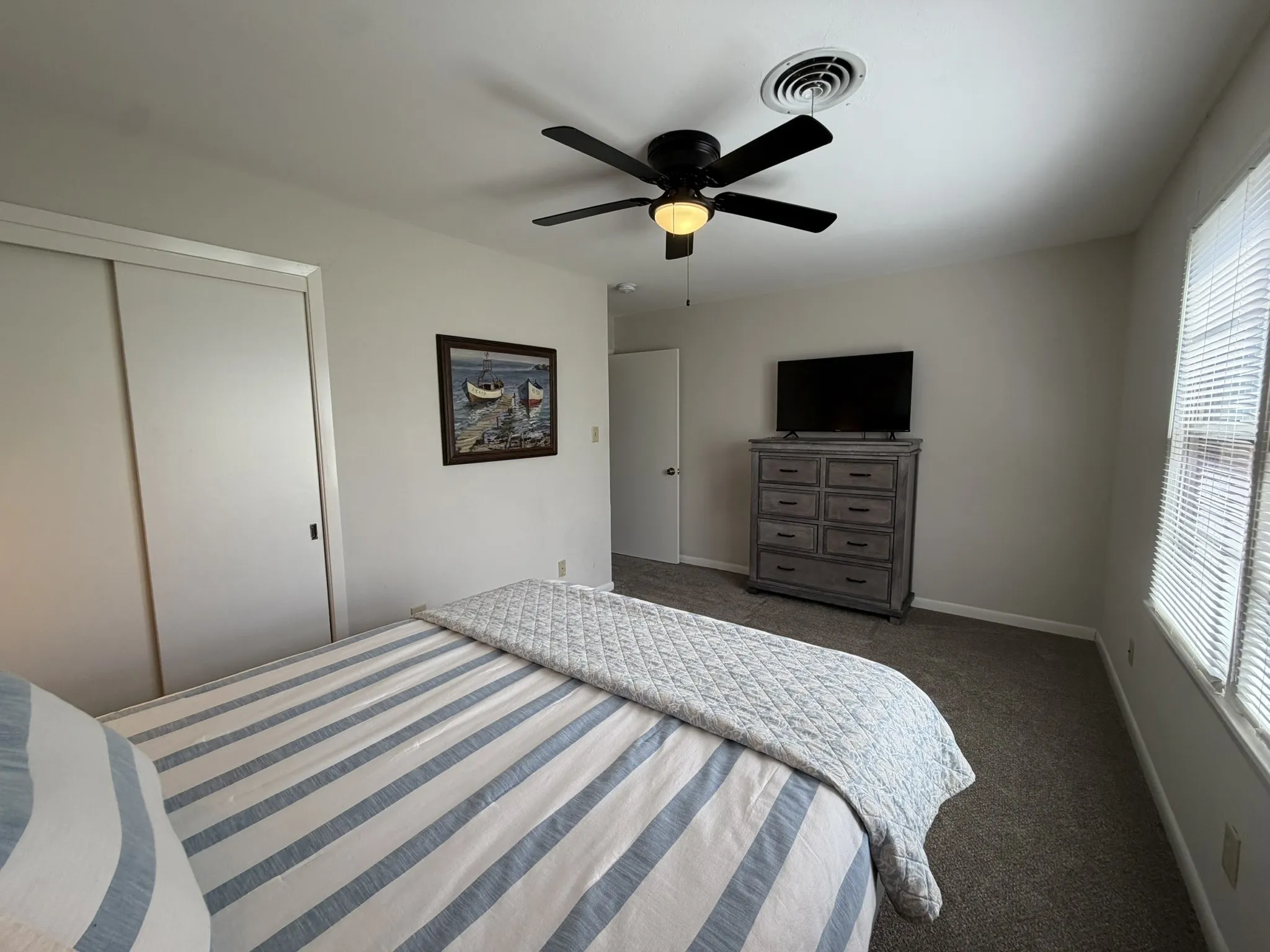 3rd bedroom with ceiling fan and carpet