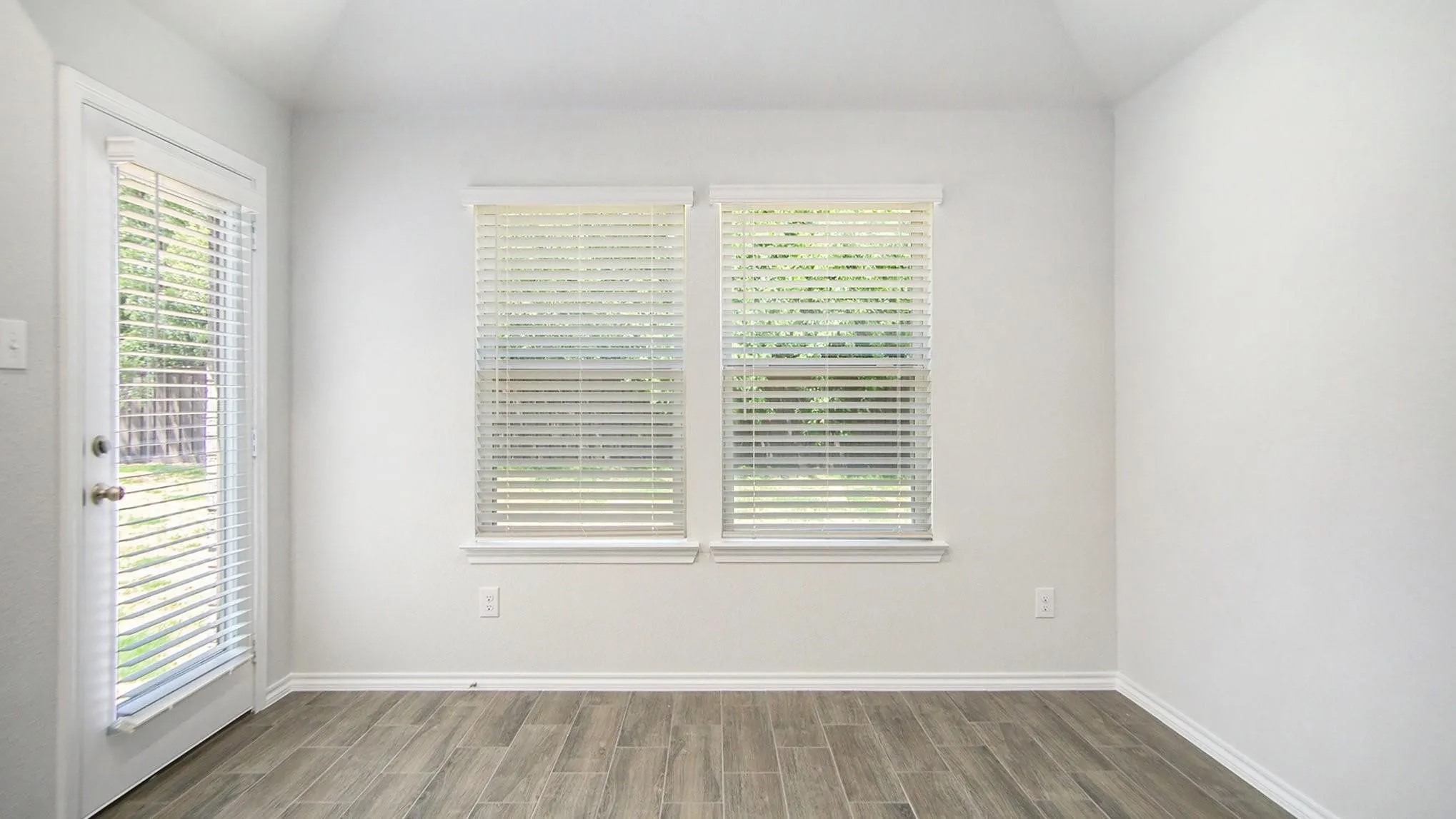 Room featuring wood-look tile flooring, white baseboards, and a neutral wall color