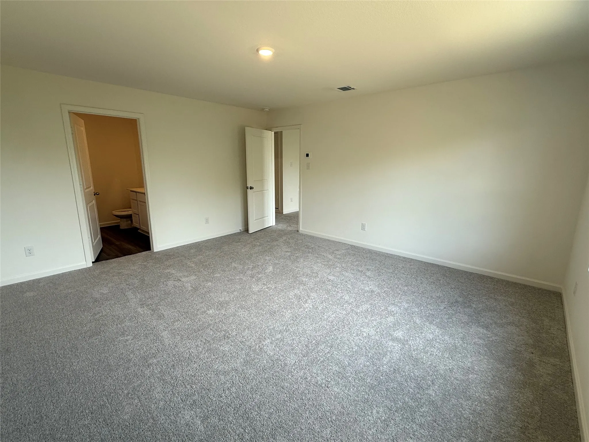 Spacious room with light-toned carpeting and neutral wall tones
