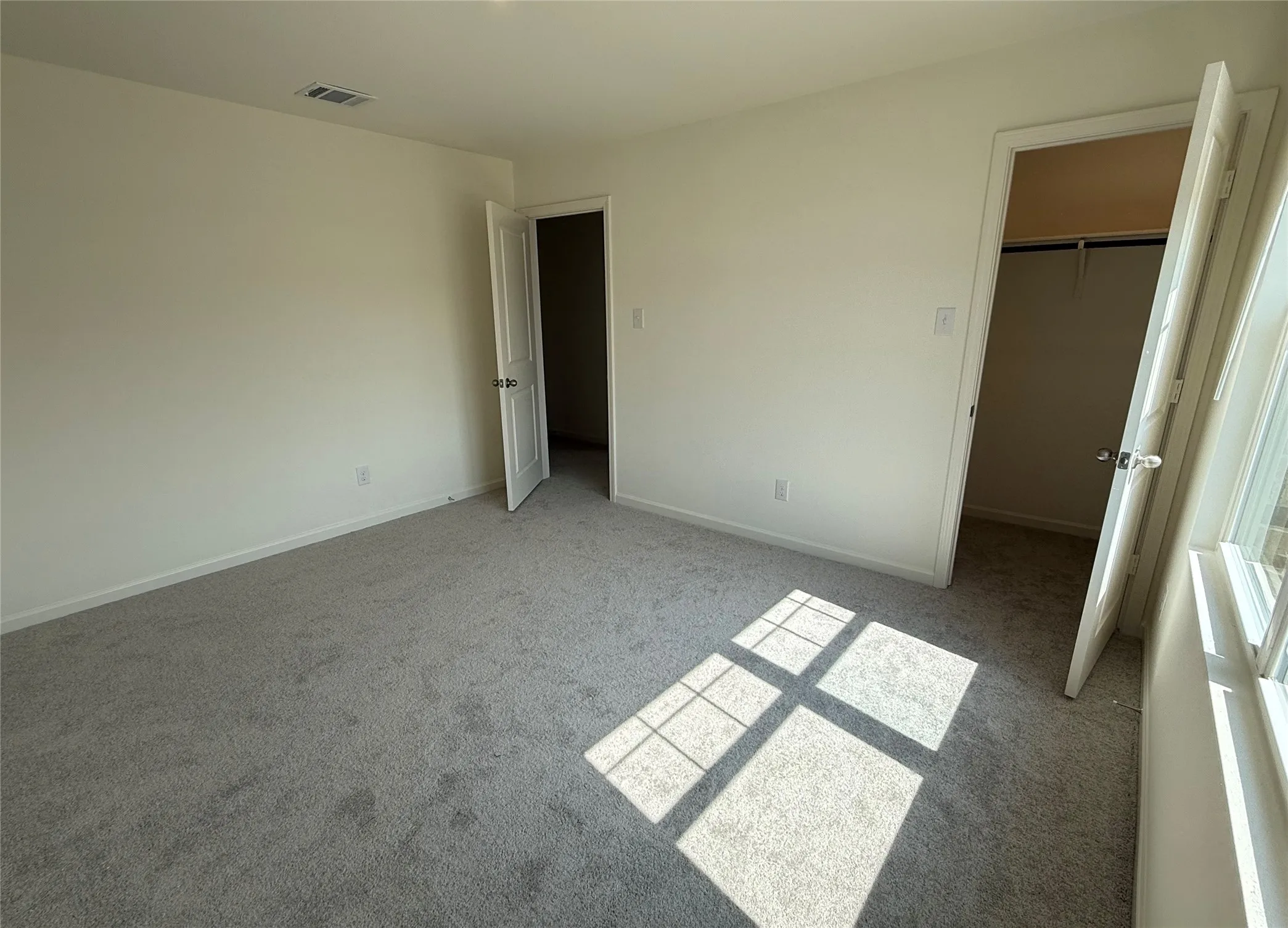 Neutral-toned walls and plush gray carpeting