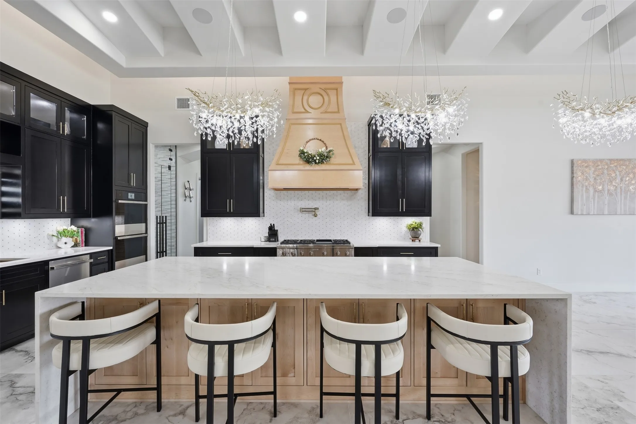 Gourmet kitchen featuring a waterfall-edge island with wood-finish base, quartz countertops, and seating for four