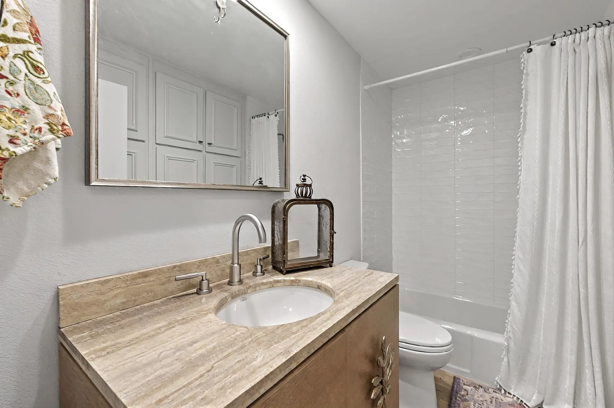 Bathroom featuring a vanity with an integrated sink, stone countertop, brushed nickel faucet, and a tiled shower-over-tub