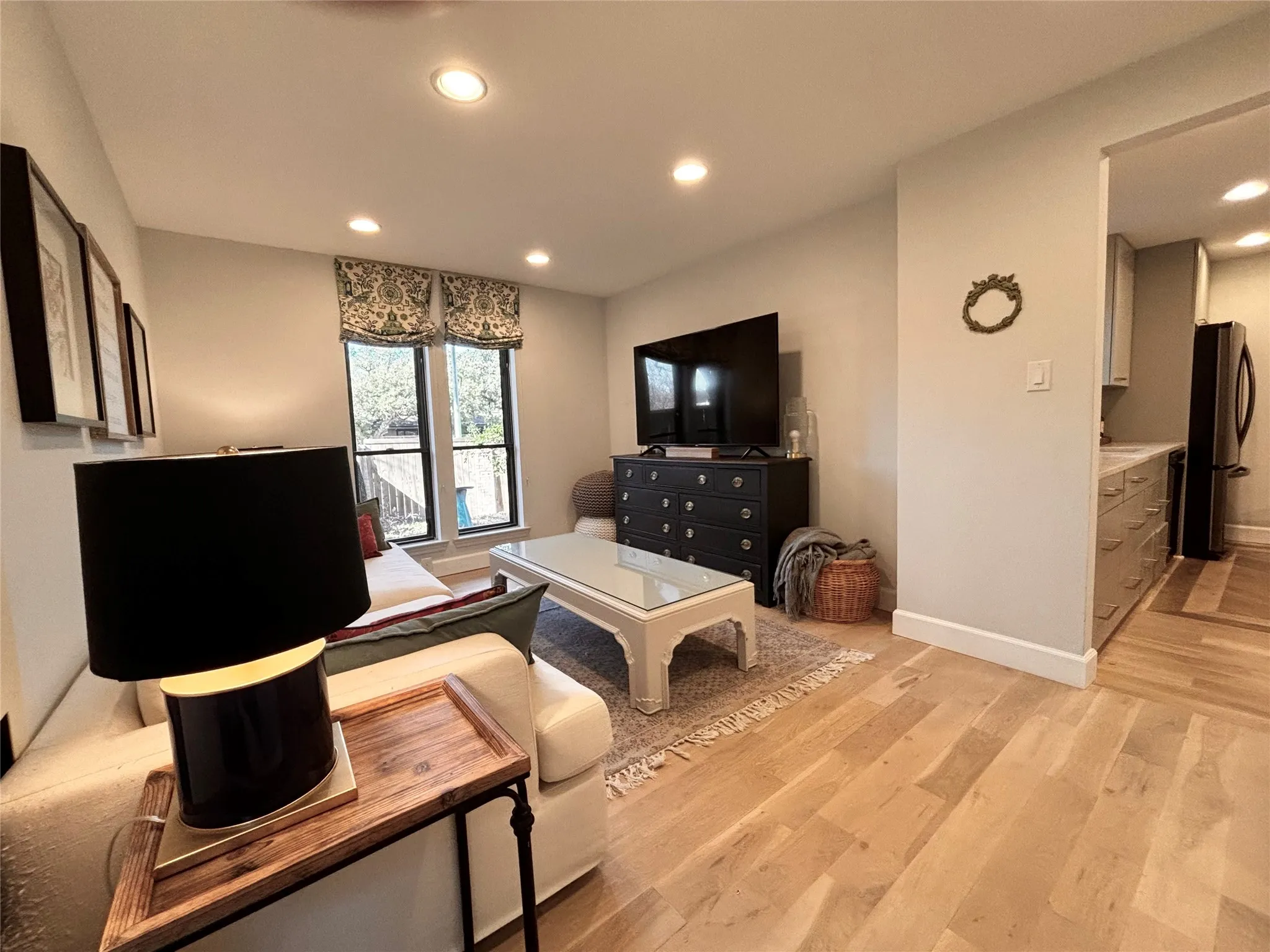 Recessed lighting, wood-finish flooring, and white baseboards