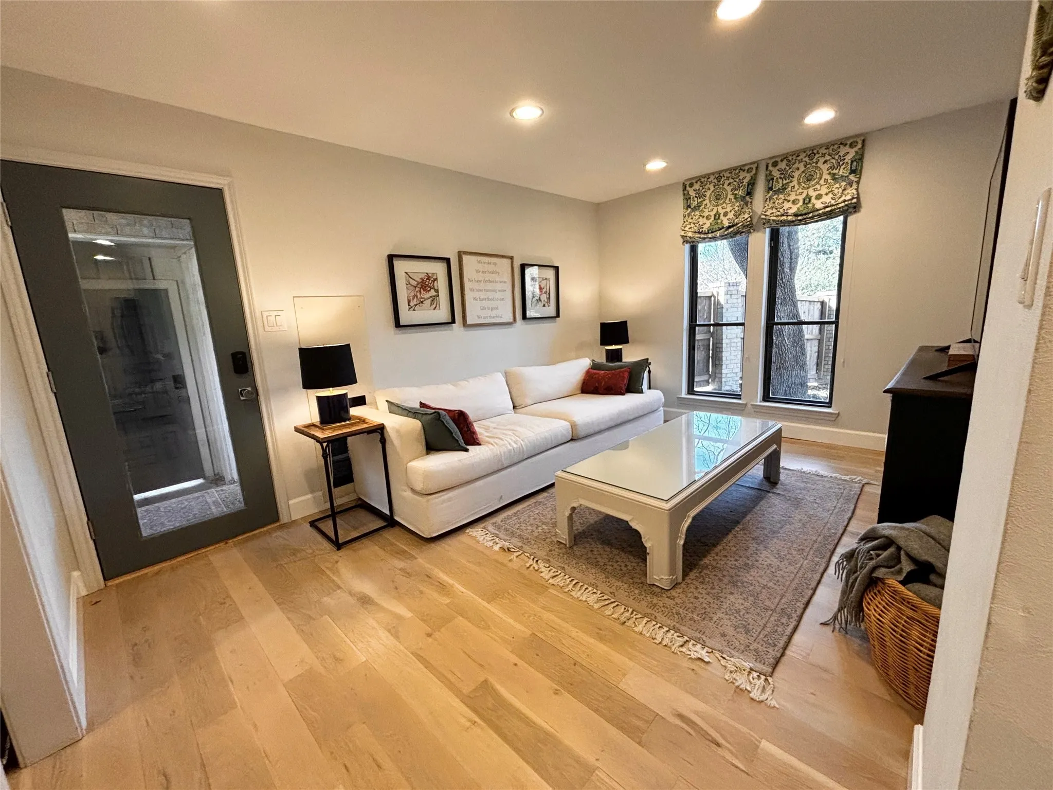 Recessed lighting, light wood-finish flooring, and a full-light panel door