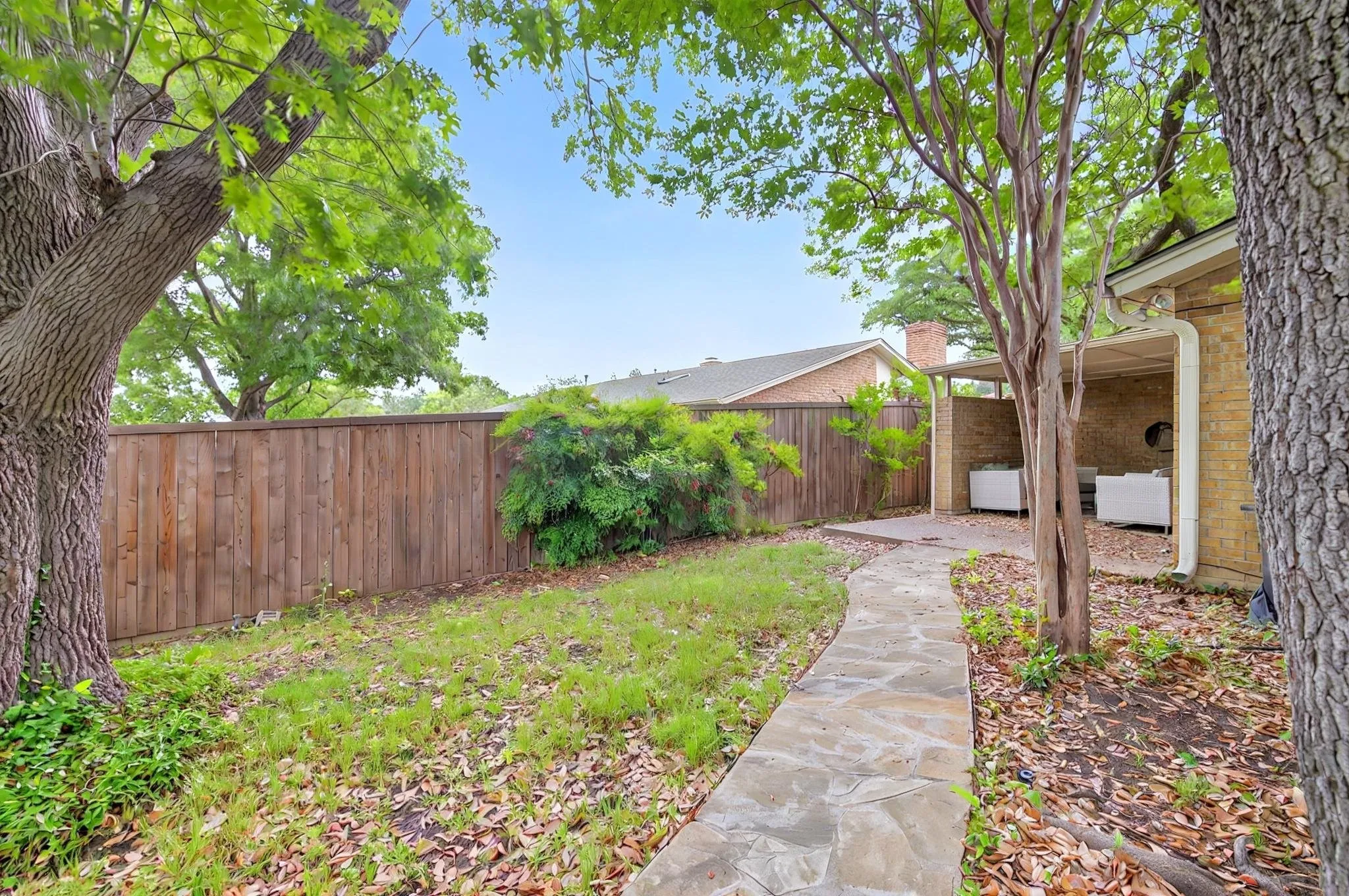 Paved stone pathway leading to a covered patio