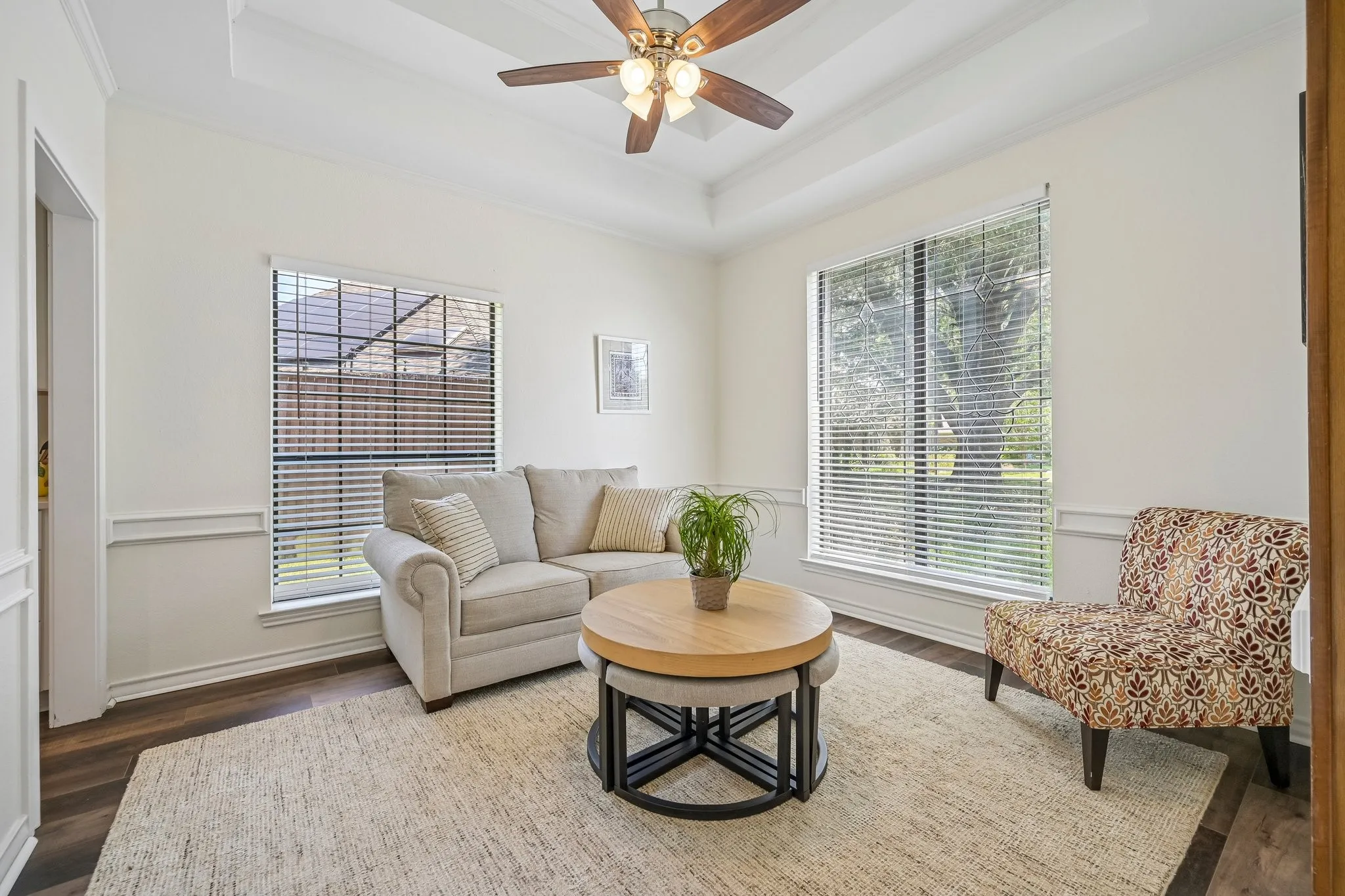 Bright sunroom flooded with natural light through dual multi-pane windows with horizontal blinds