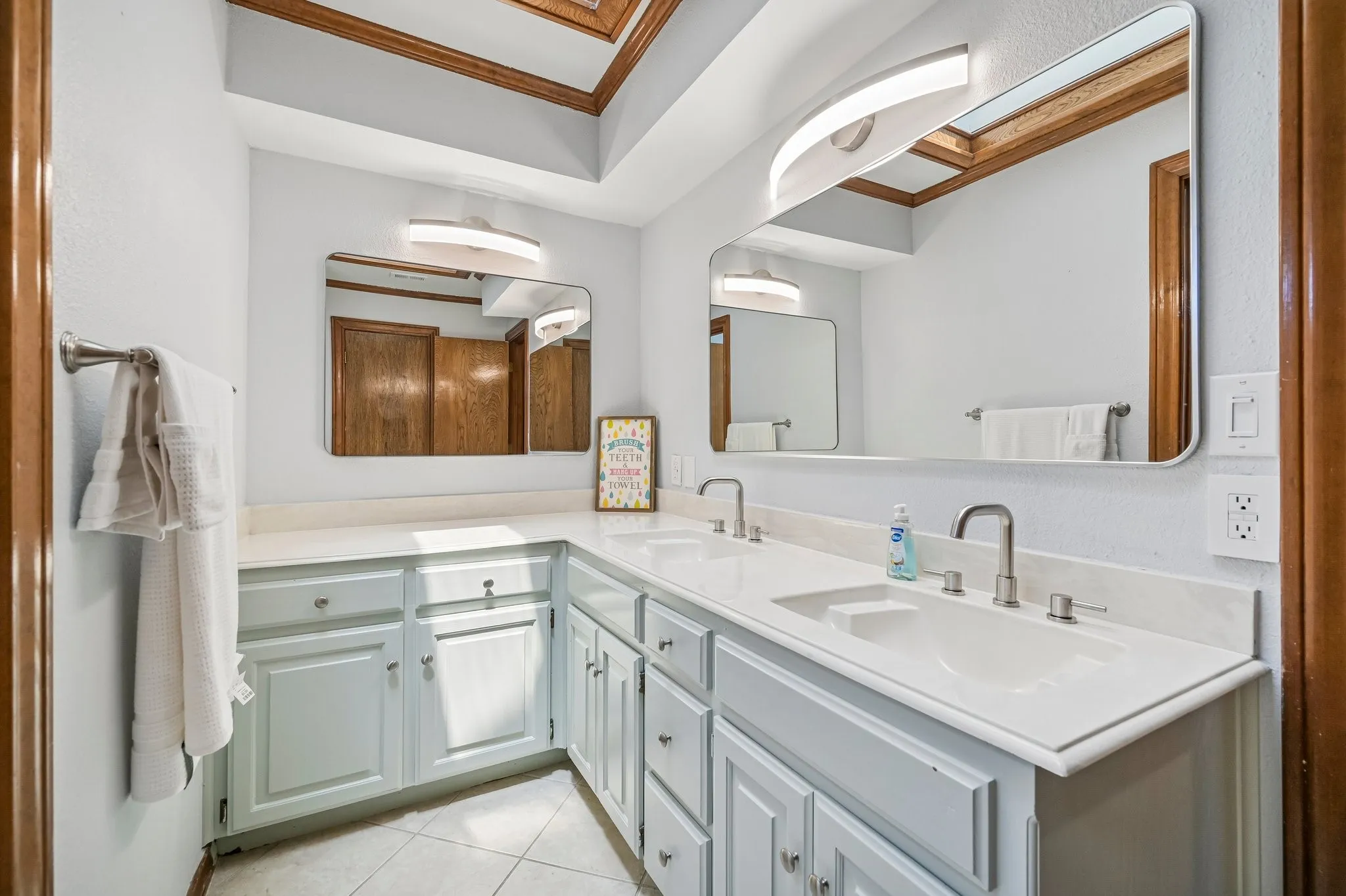 Dual vanity with integrated sinks, brushed nickel faucets, and light-toned cabinetry