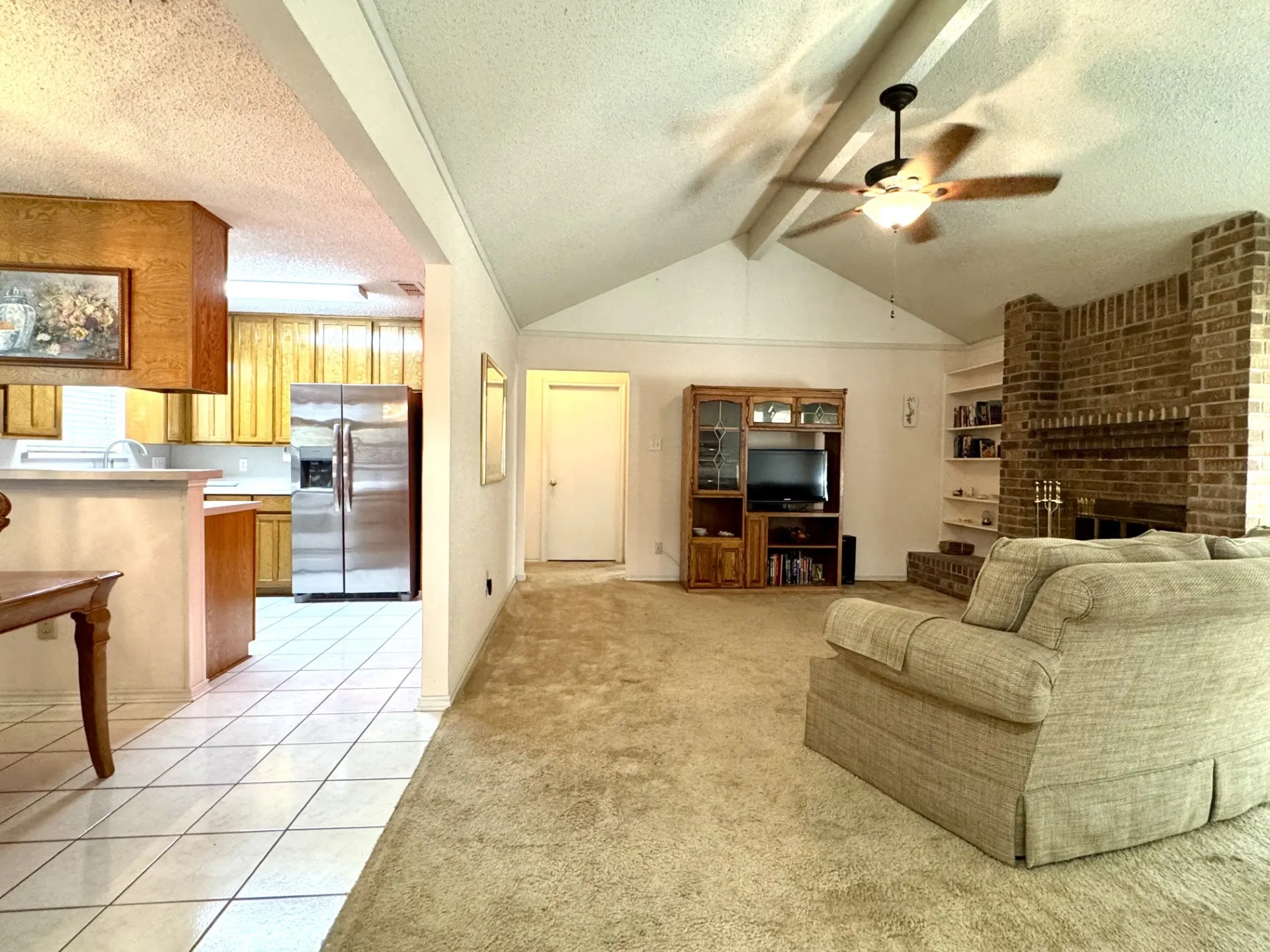 OPEN Layout! Spacious Living Room: brick fireplace, built-in shelves, vaulted ceiling with fan. Wood cabinet Entertainment Center conveys with acceptable offer.