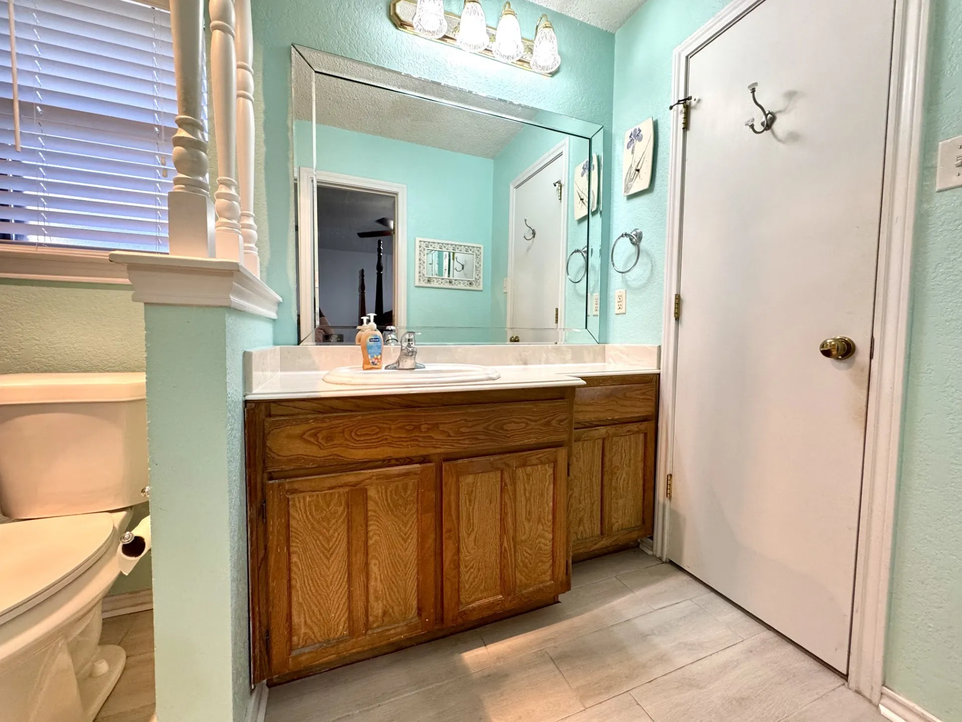 Primary Bathroom ENSUITE: vanity with single sink, framed mirror with overhead light fixture, and ceramic tile flooring. Walk-In CLOSET inside Ensuite Bath.
