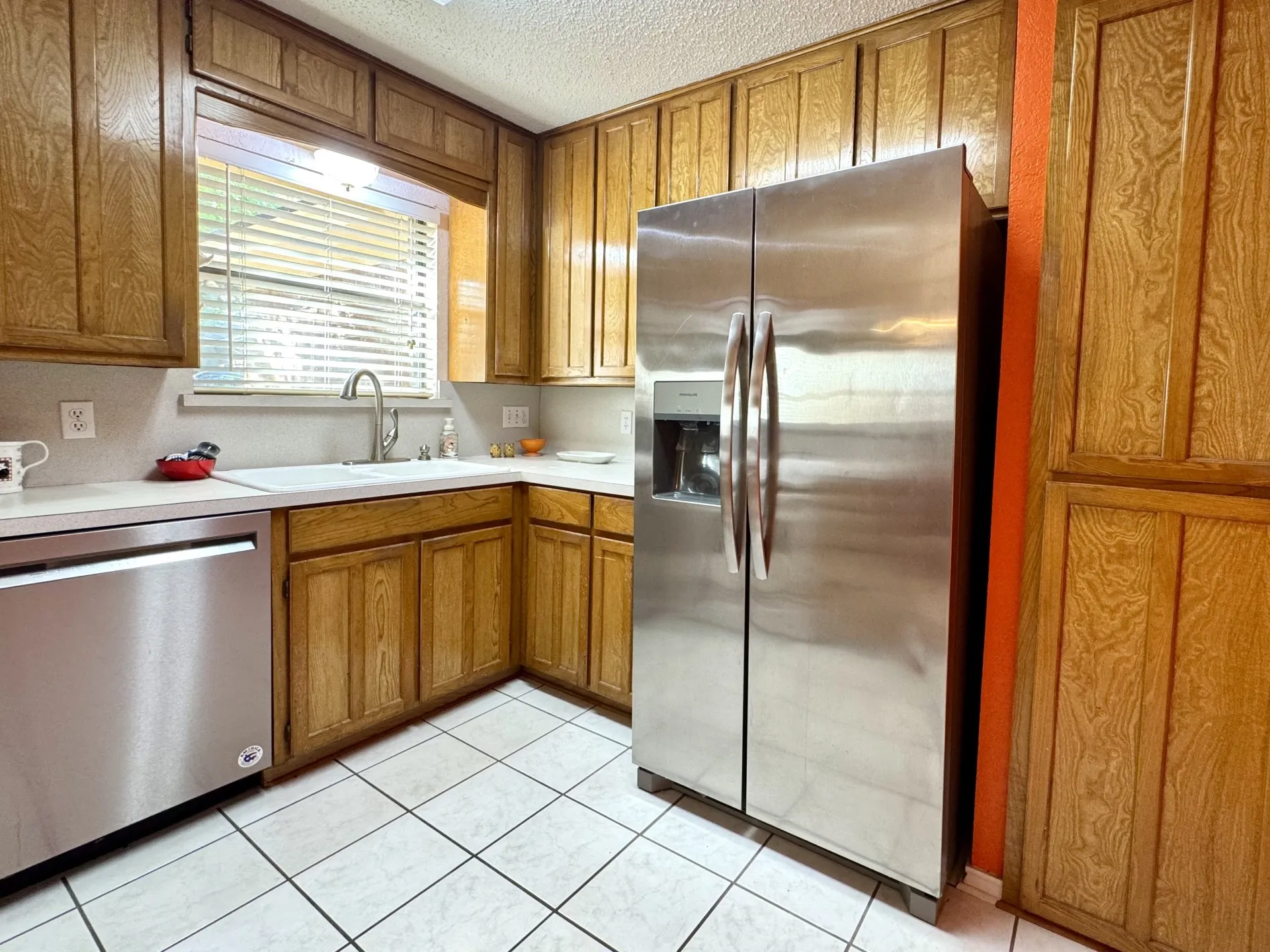 Kitchen Fridge CONVEYS! Nice double-basin sink, PANTRY wood cabinets, stainless steel appliances, white countertops, and white ceramic tile flooring.