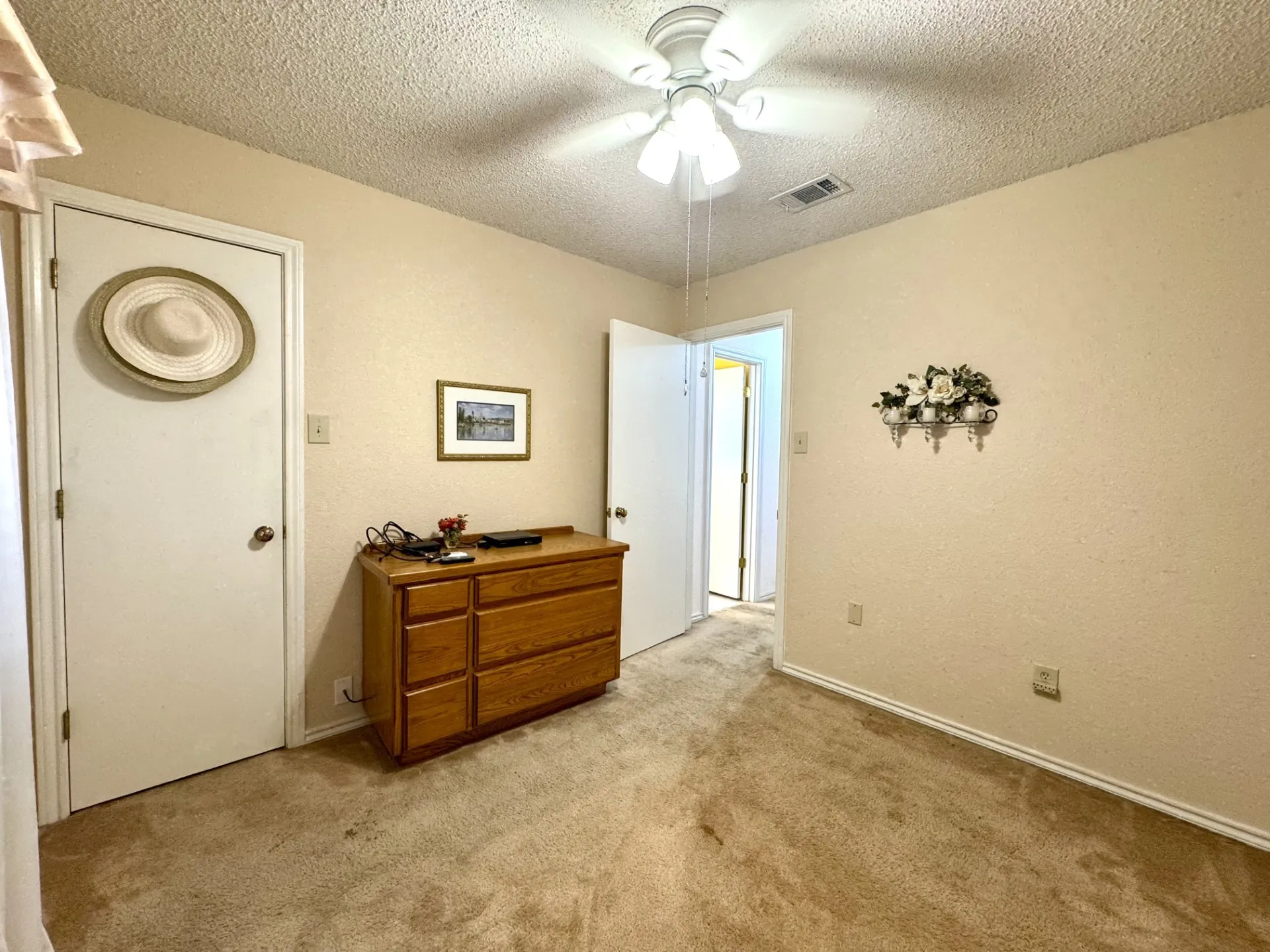 Back Bedroom 3 is SPLIT from Primary: walk-in closet, carpeting, and ceiling fan.