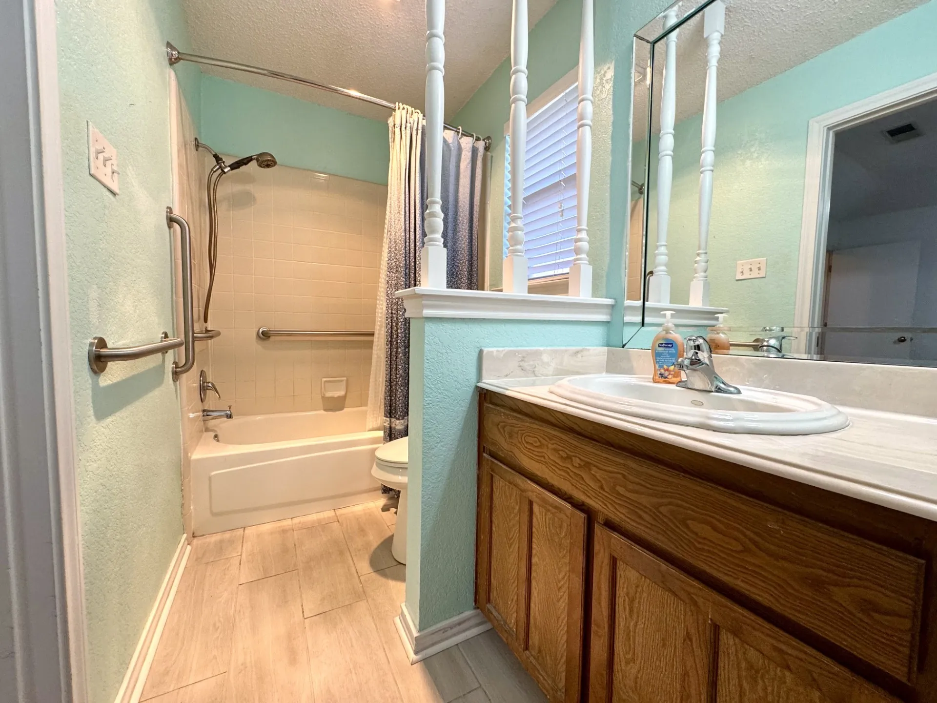 Primary Full Bath Ensuite: Tub-shower Combo with convenient grab-bars, single sink vanity, and large walk-in closet (not shown).