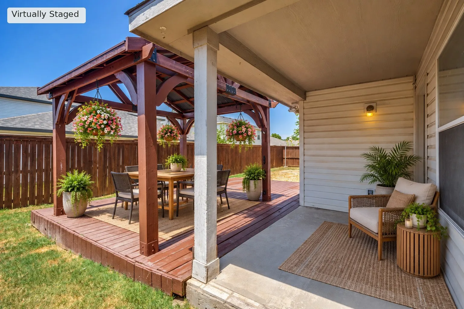 Covered patio area with concrete flooring, accented by a wood pergola over a raised wood deck