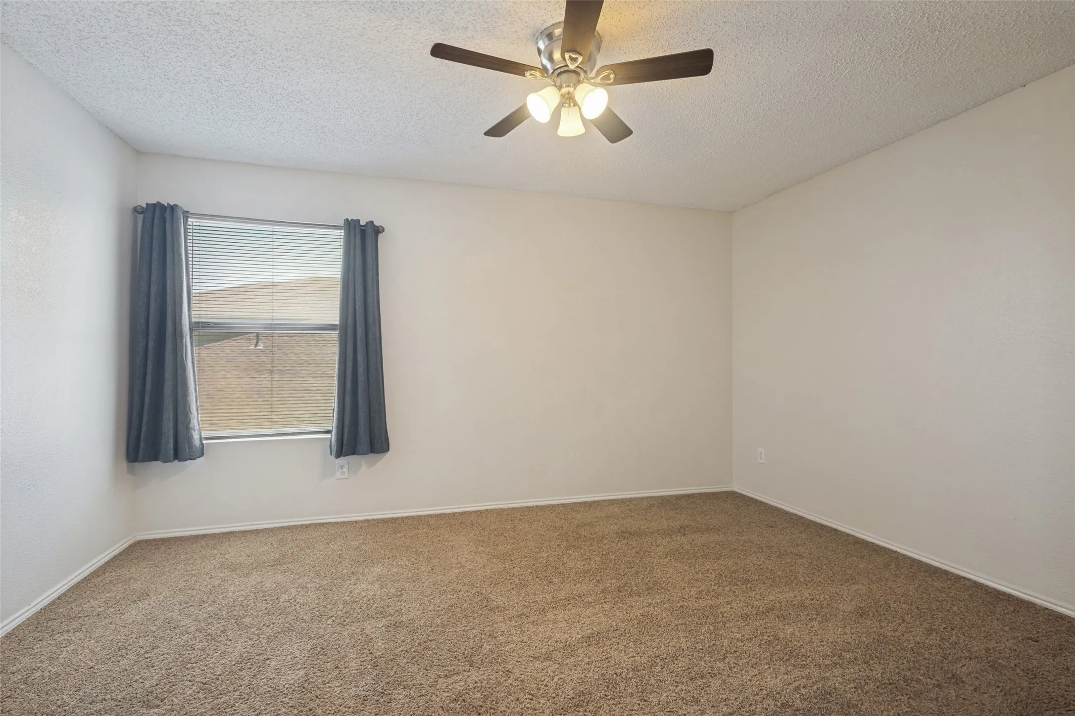 Carpeted room featuring a ceiling fan with integrated lighting