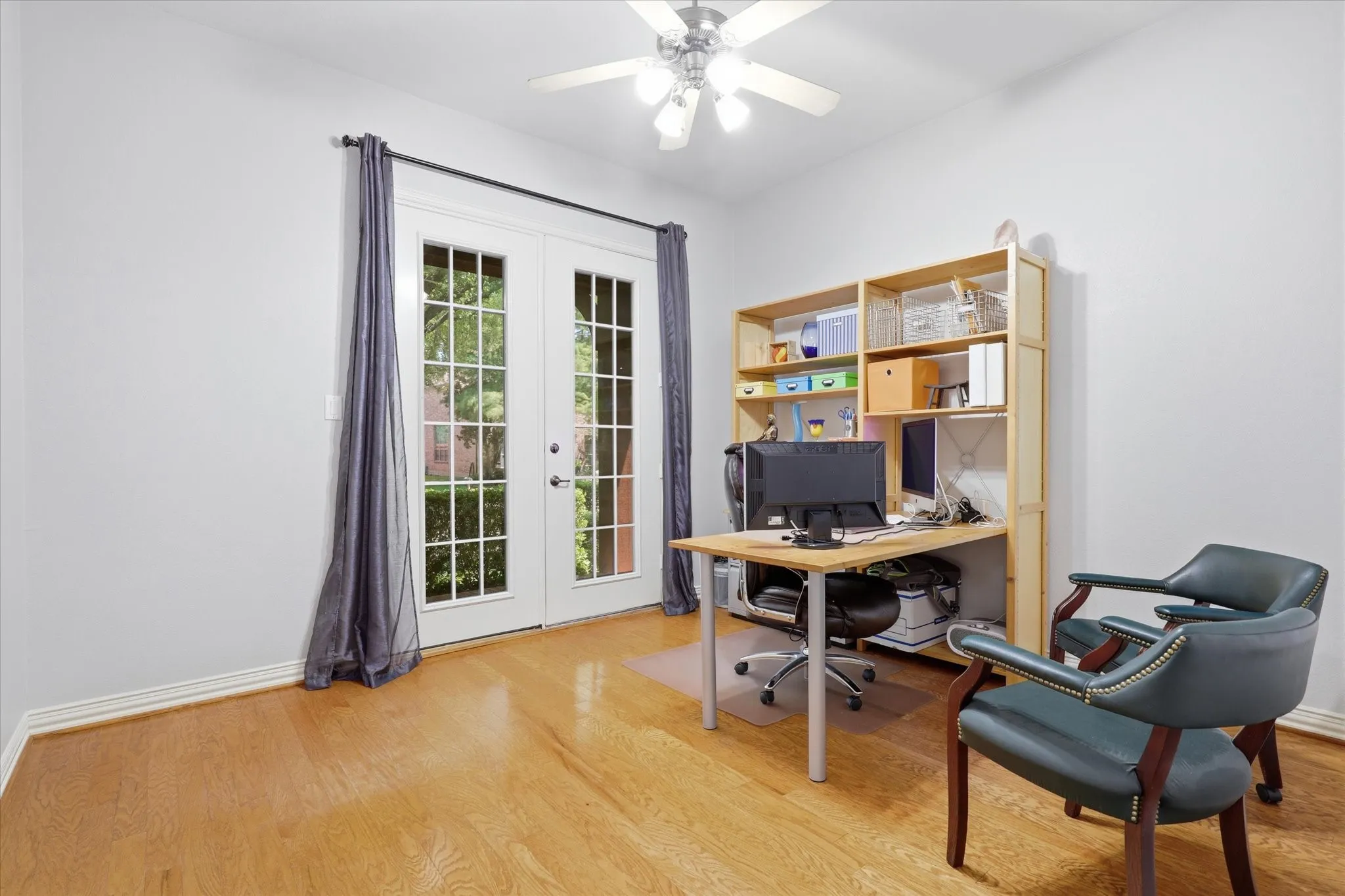 Office in the front of the home offers wood flooring and doors to the front porch.