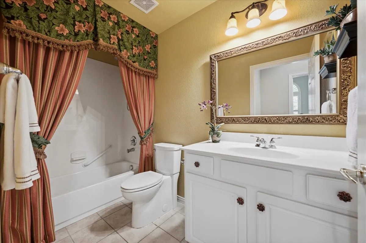 guest bath next to front bedroom - has linen closet also; combo tub shower picture prior to curtain removed and updated paint color