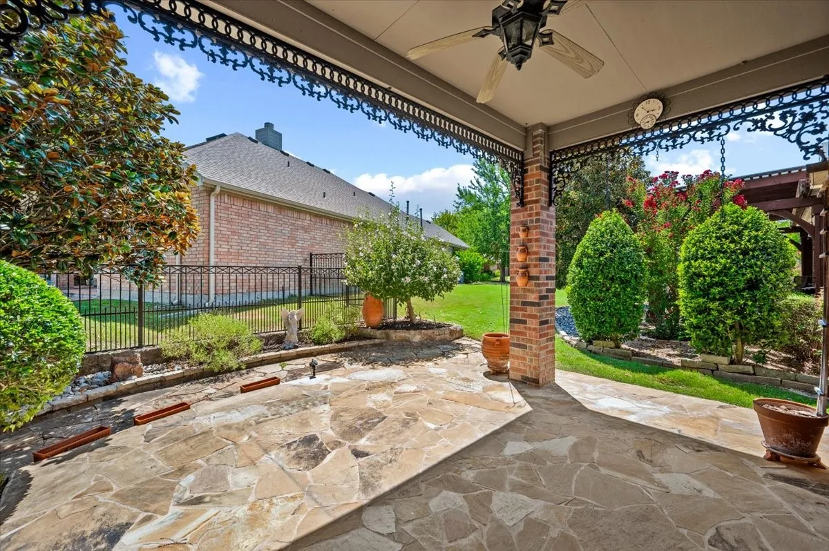 Extended flagstone patio, ceiling fan, decorative ceiling, trees and shrubs provide privacy