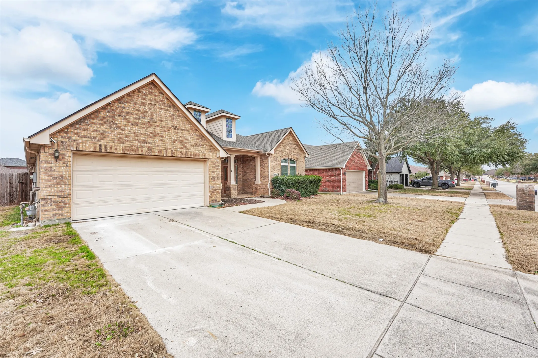 Brick and stone exterior with a two-car garage and concrete driveway