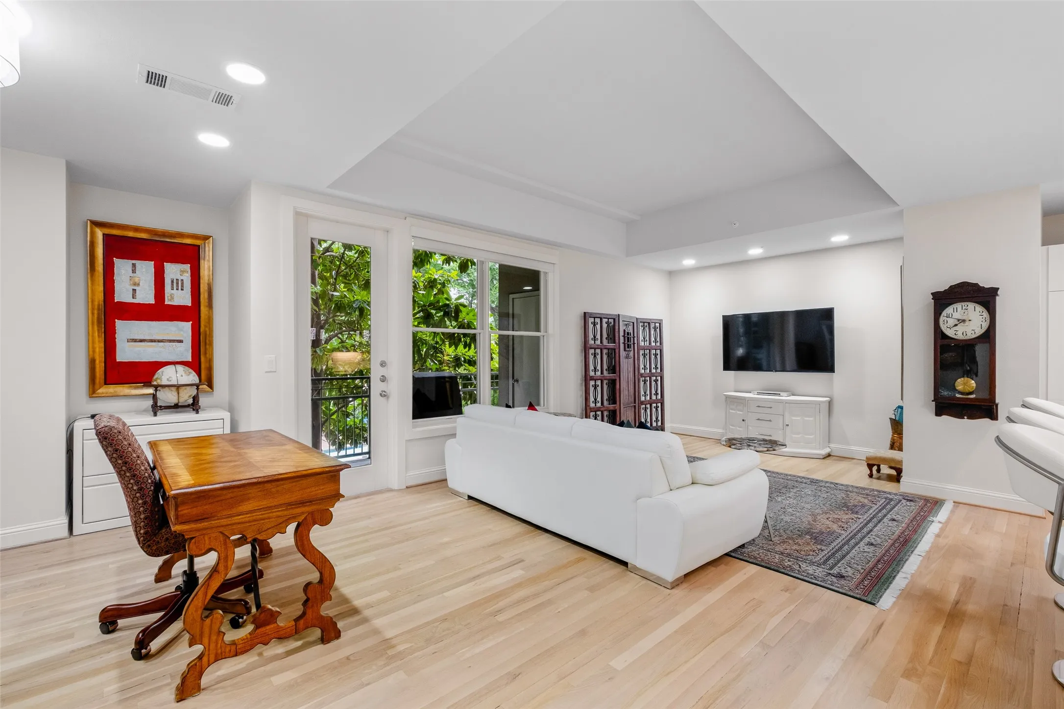 Recessed lighting, light wood-finish flooring, and French doors leading to a balcony