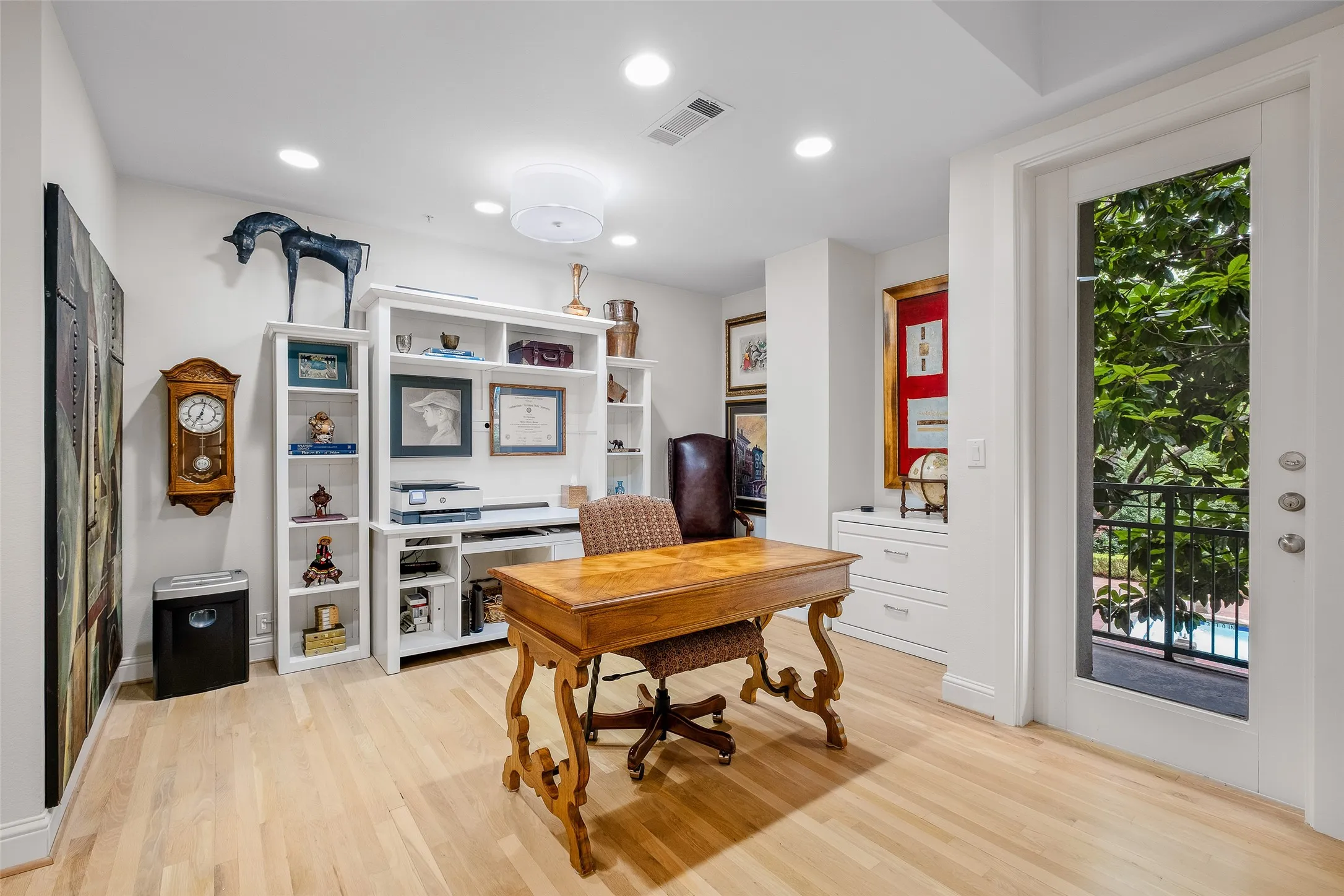Recessed lighting, wood-finish flooring, built-in shelving, built-in cabinetry, and a glass-paneled door