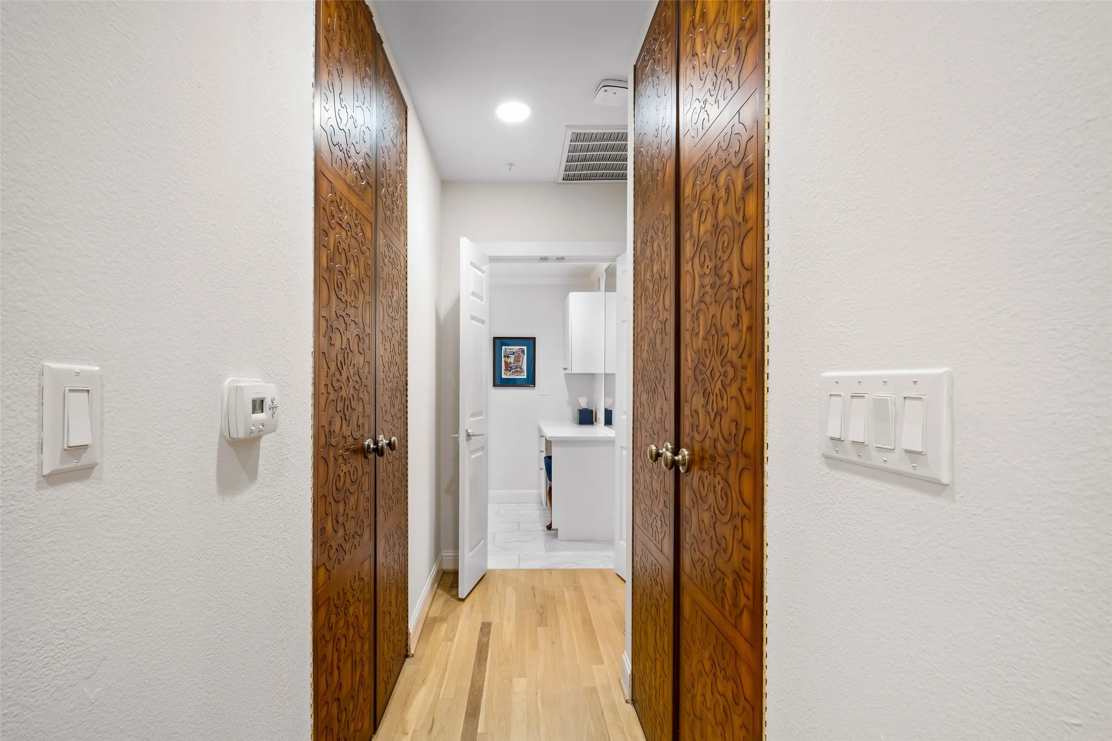 Hardwood-finish flooring, recessed lighting, and ornate wood-finish doors