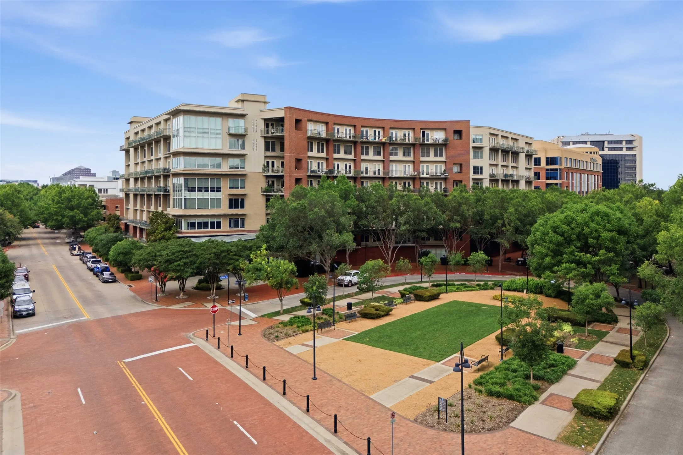 Multi-story building featuring brick and stucco facades, multiple balconies, and large windows