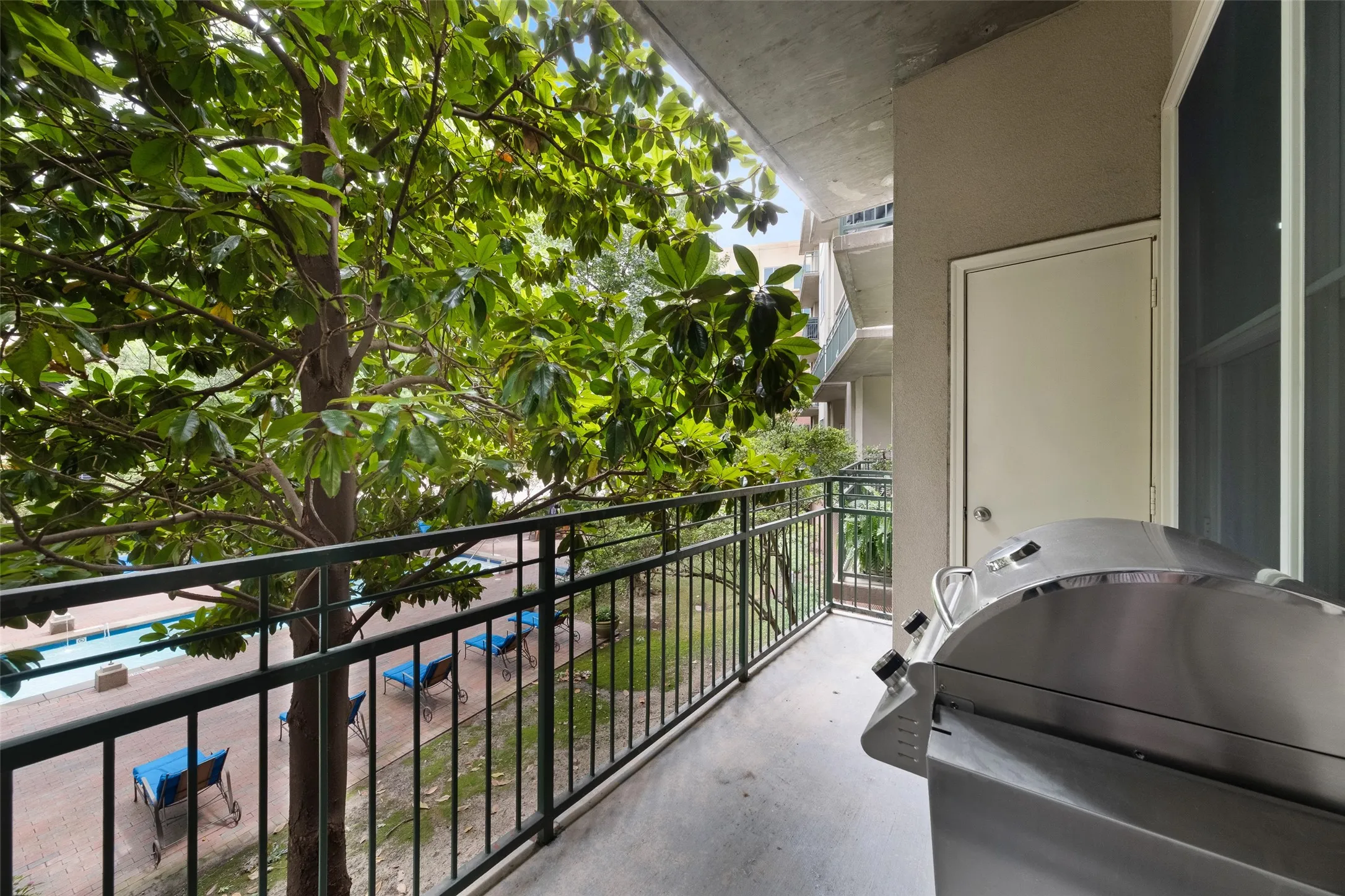 Private balcony with a dark metal railing, an exterior door, and an exterior window