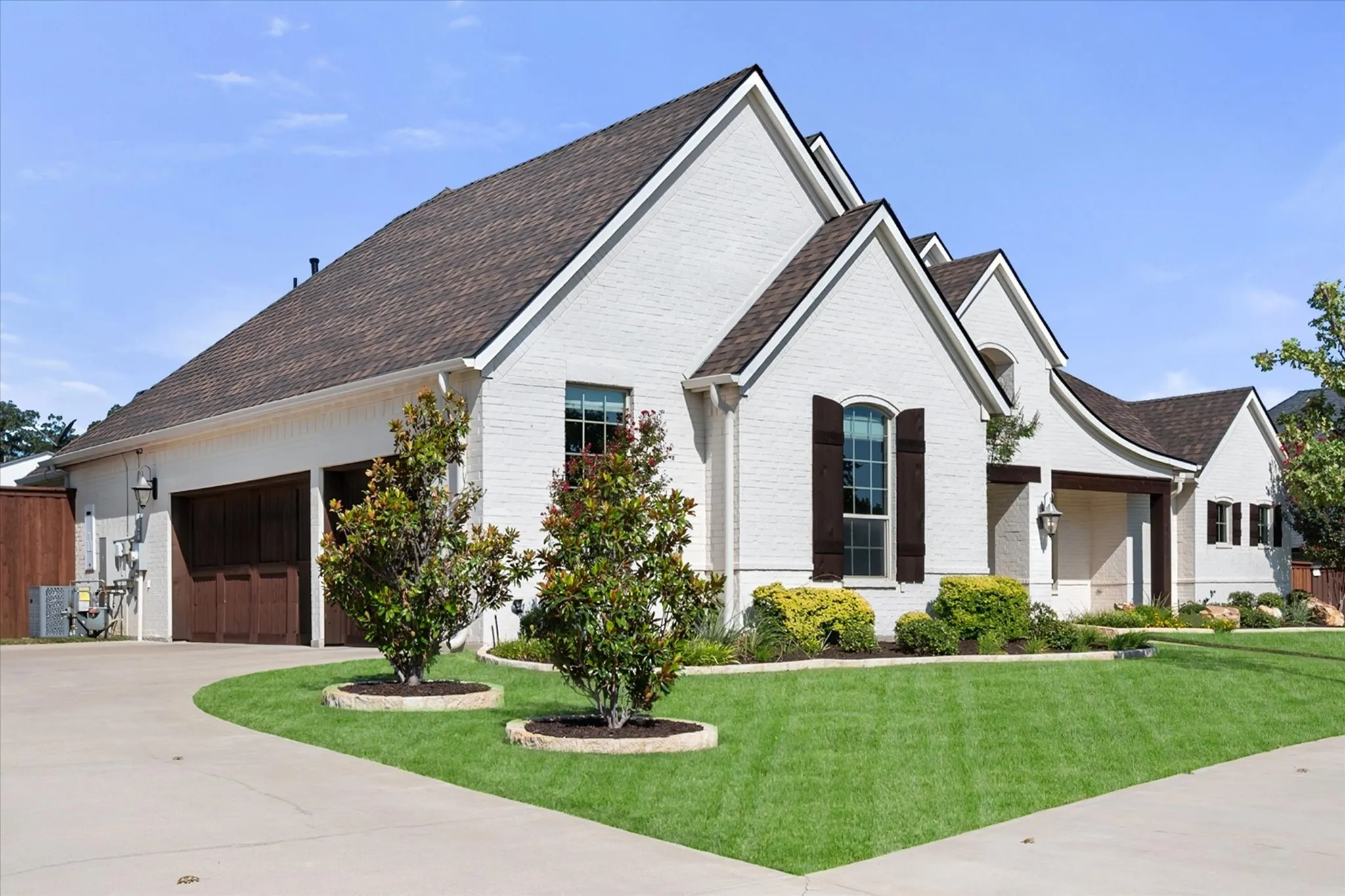Striking contemporary home featuring a clean white exterior with multiple gabled rooflines and dark architectural accents