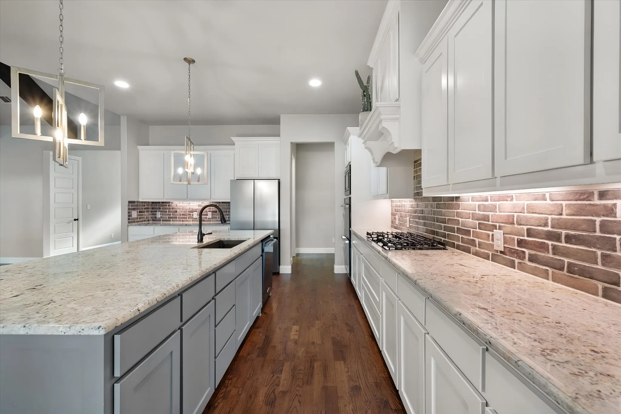 Chef's kitchen featuring white cabinetry with soft-close drawers, quartz countertops, stainless steel appliances, and a large center island with seating