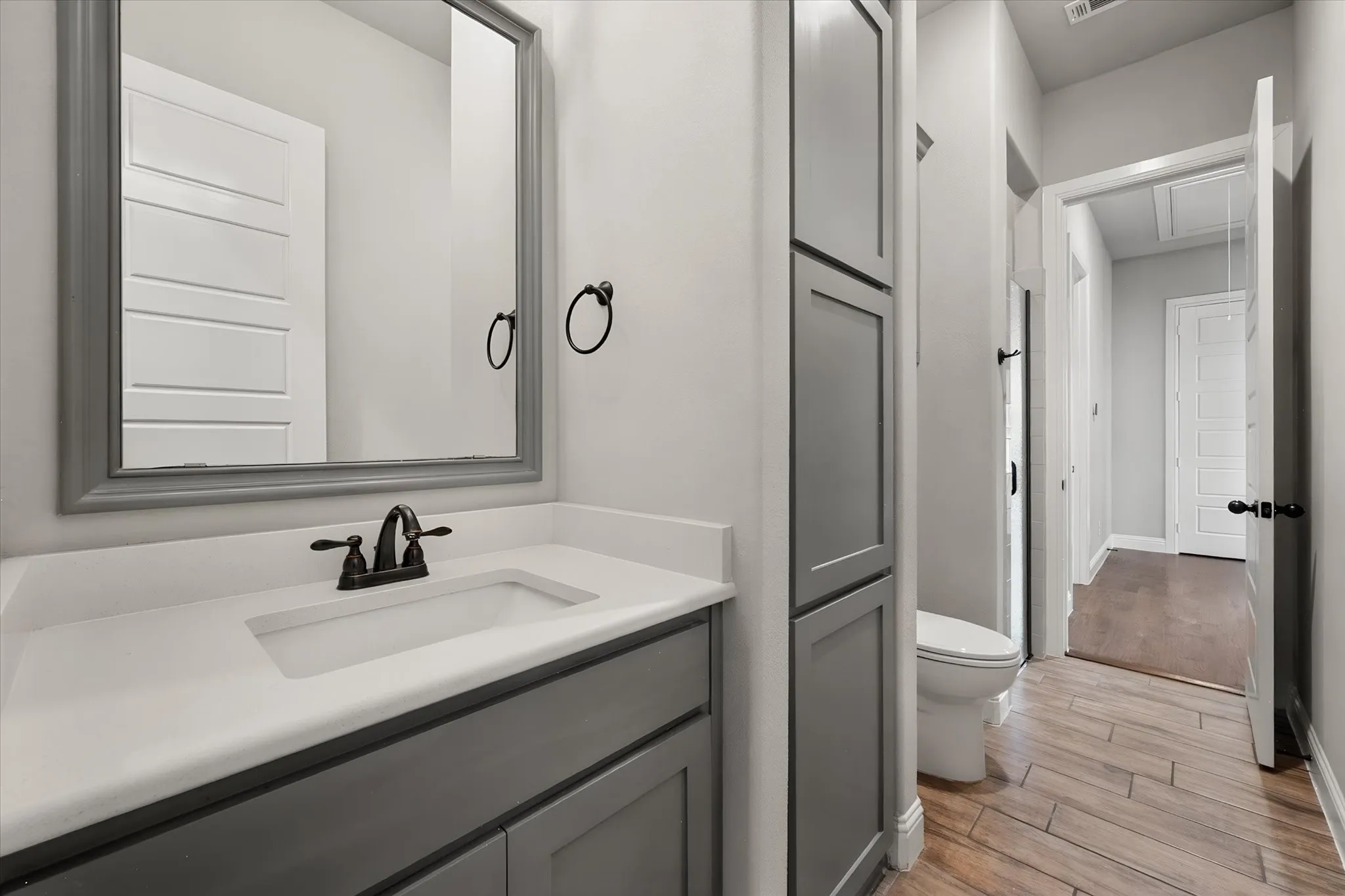 Modern bathroom featuring a single vanity with quartz countertop, integrated sink basin, and matte black faucet hardware