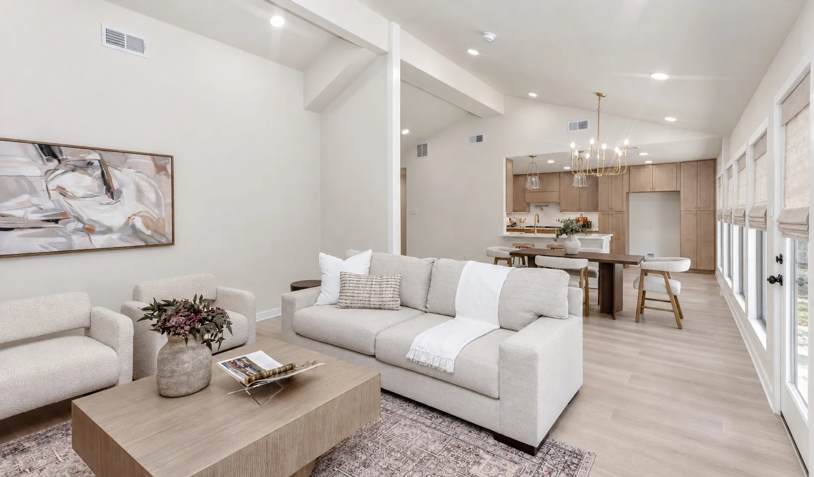 Vaulted ceilings with wall of windows, recessed lighting, wood-finish flooring, add to the contemporary look