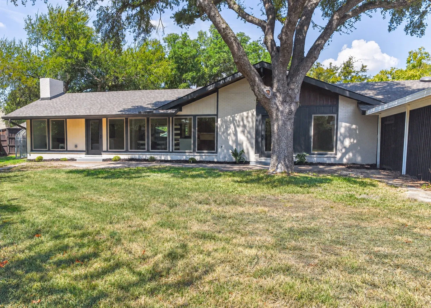 Large grassy backyard with greenhouse at one end and 2+ car carport-with room for your golfcart & attached storage building at the other end