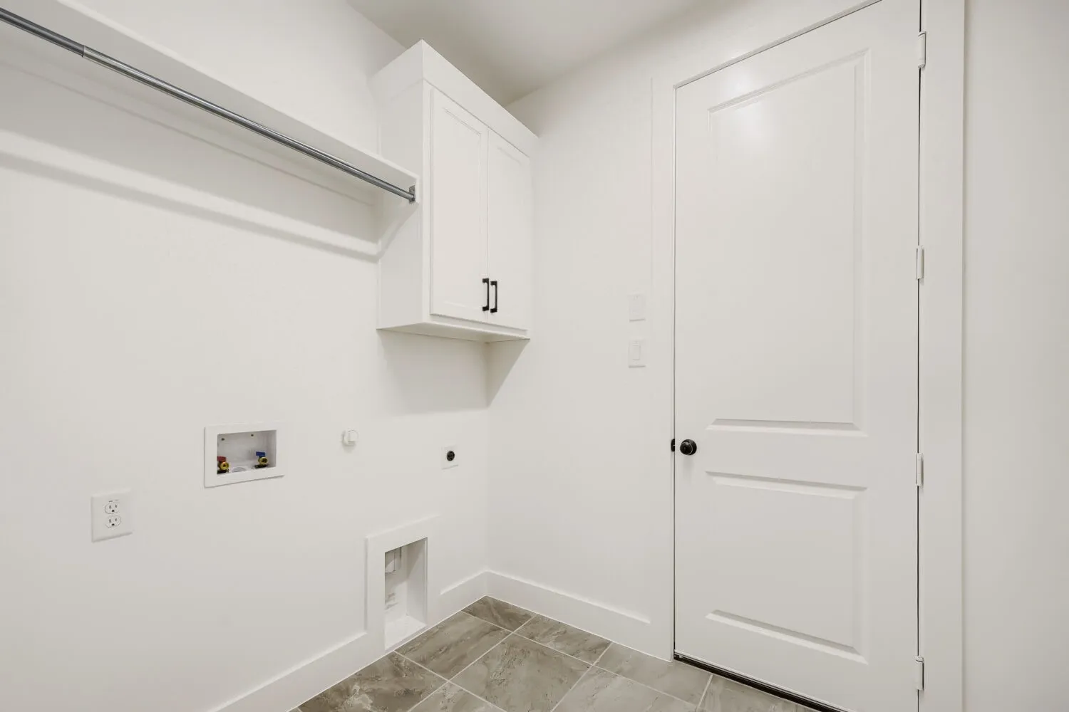Built-in cabinetry, wall-mounted hanging rod, and neutral-toned floor tiling