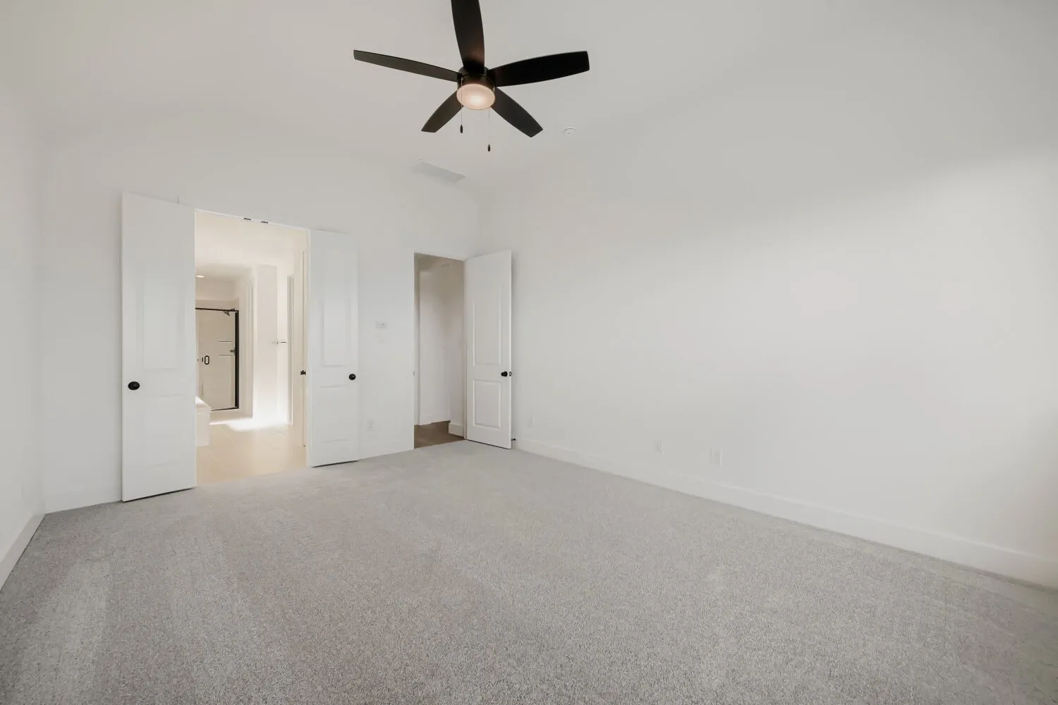 Vaulted ceiling with a ceiling fan, light gray carpet, and white walls