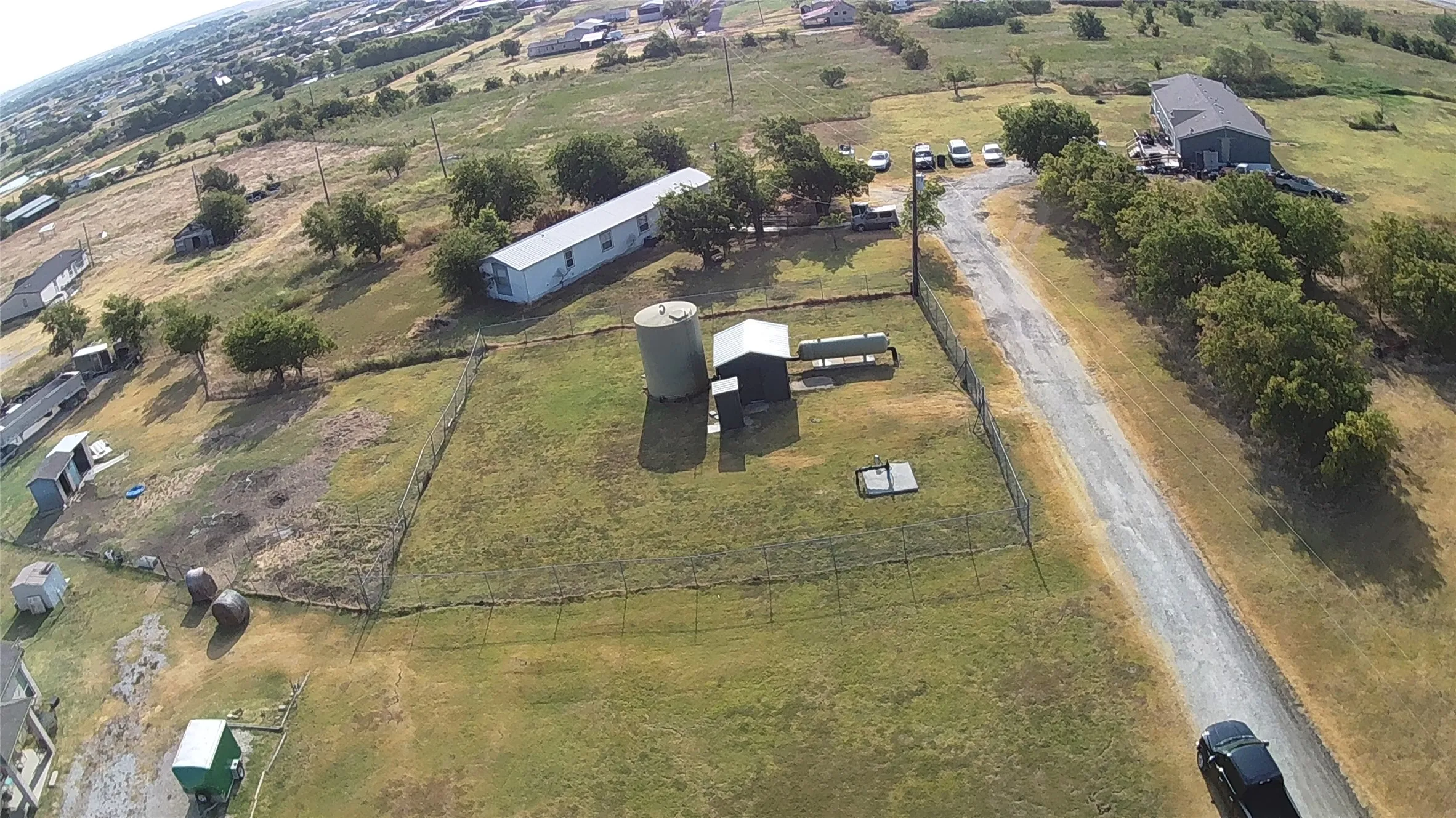 Expansive rural property featuring multiple outbuildings, including a large white agricultural structure and several storage barns situated on manicured grounds